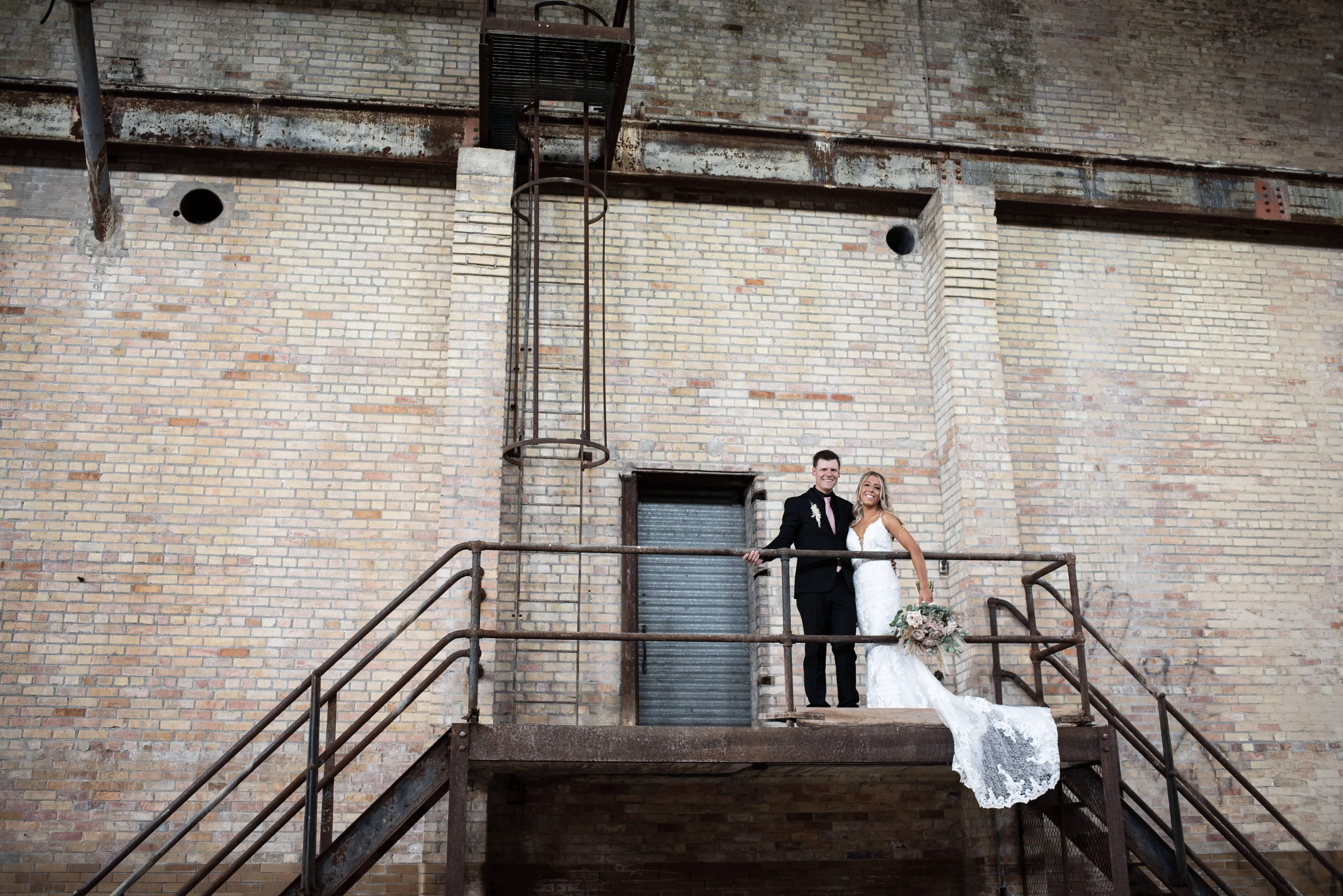 Bride with groom wearing romantic lace sheath wedding dress.