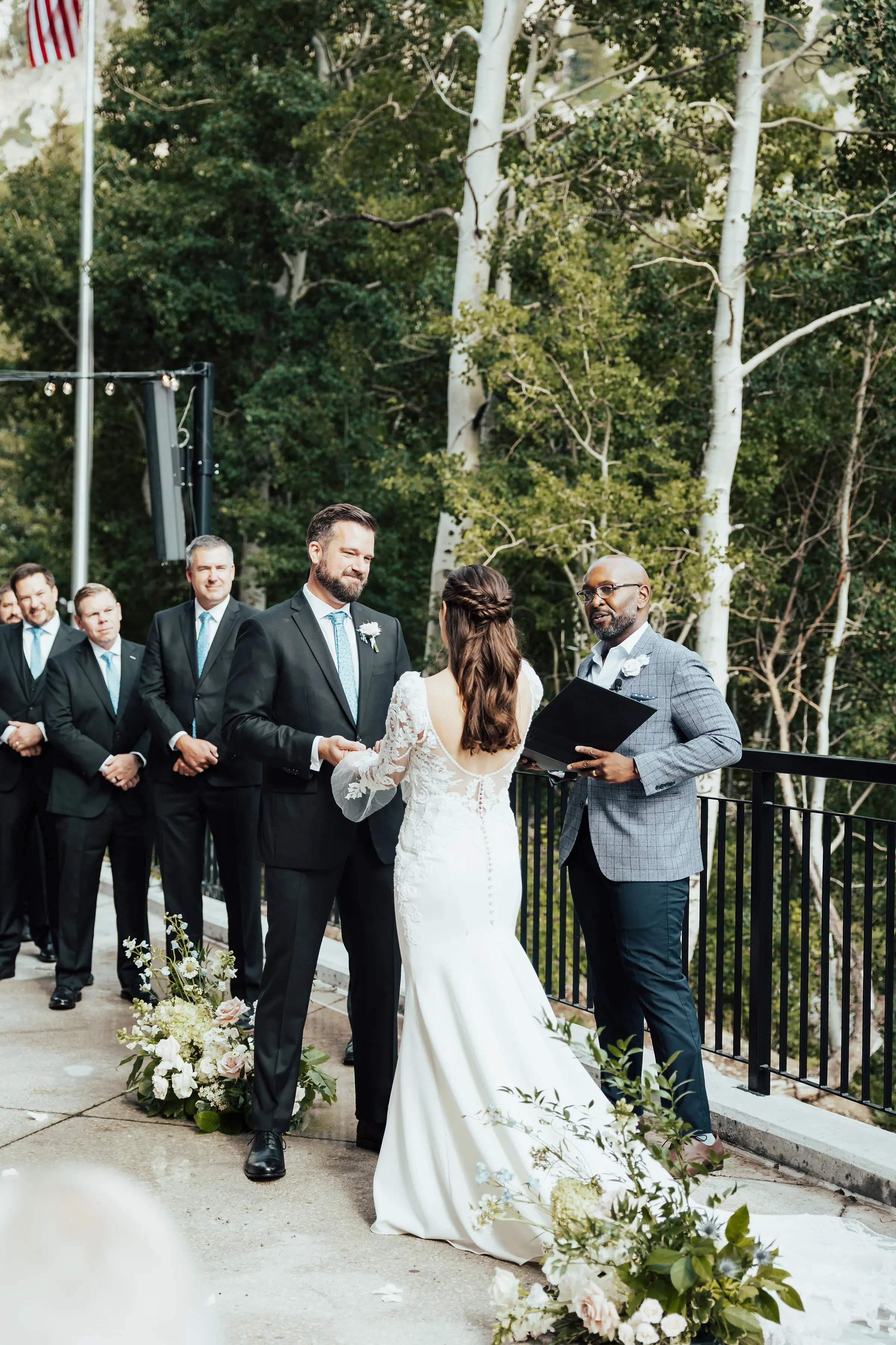 Bride Wearing Long Sleeve Mermaid Wedding Dress with Groom Outdoors.