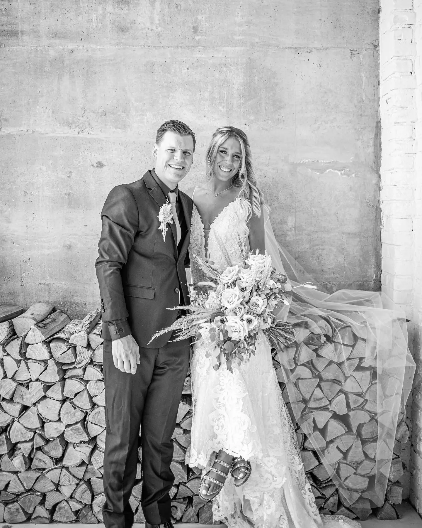 Bride with groom wearing romantic lace sheath wedding dress.