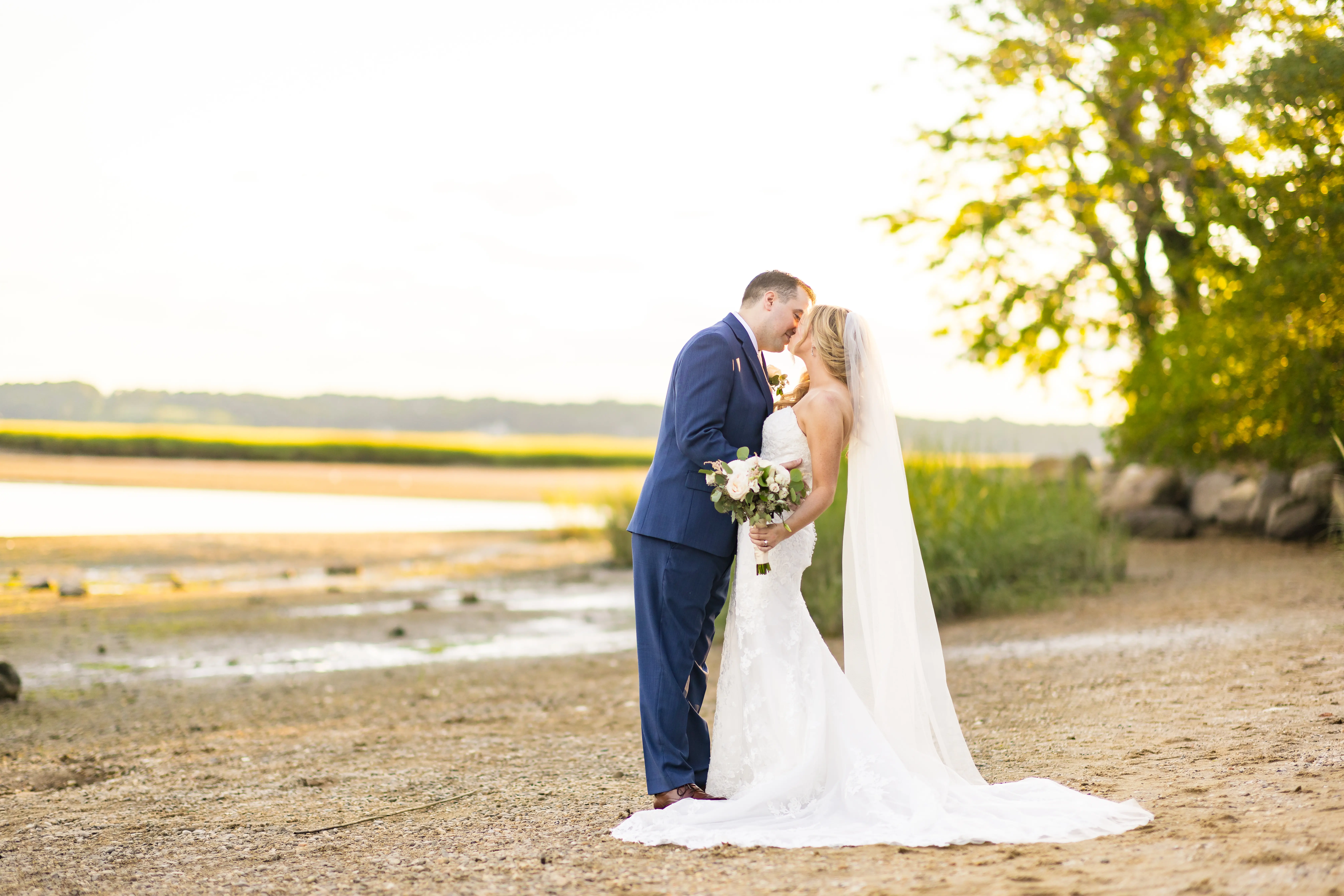 Bride Wearing 3-D Flower Fit-And-Flare Bridal Gown Named Ryker by Sottero and Midgley Bride Kissing Groom