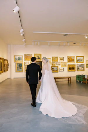 Bride wearing Mitchell Marie Vida by Maggie Sottero with her husband in a museum