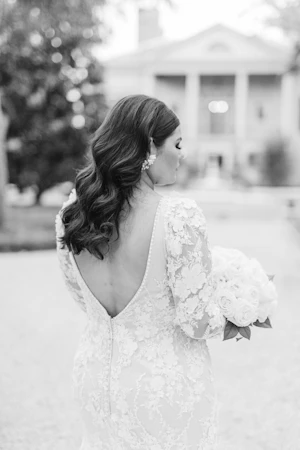 Black And White Image Of Bride Wearing Long Sleeve Lace Wedding Dress Called Cruz By Sotero And Midgley