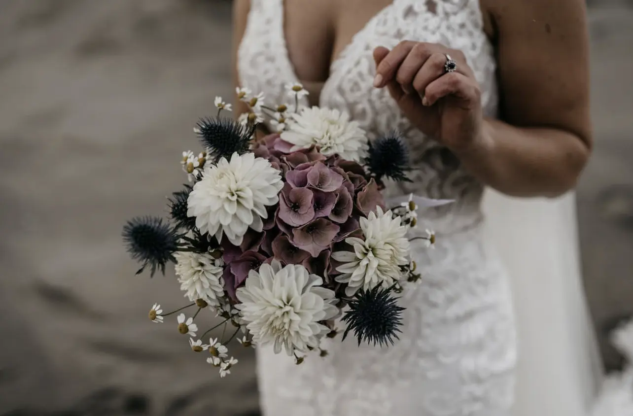 Bride Wearing Illusion Lace Back Wedding Dress Called Hamilton By Sottero And Midgley Holding White And Purple Bouquet