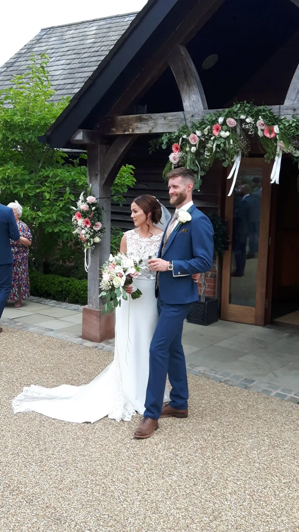 Newlyweds stood together outside their wedding venue.