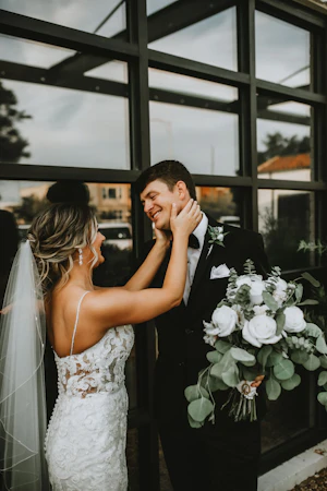 Bride with groom in romantic lace sheath wedding dress