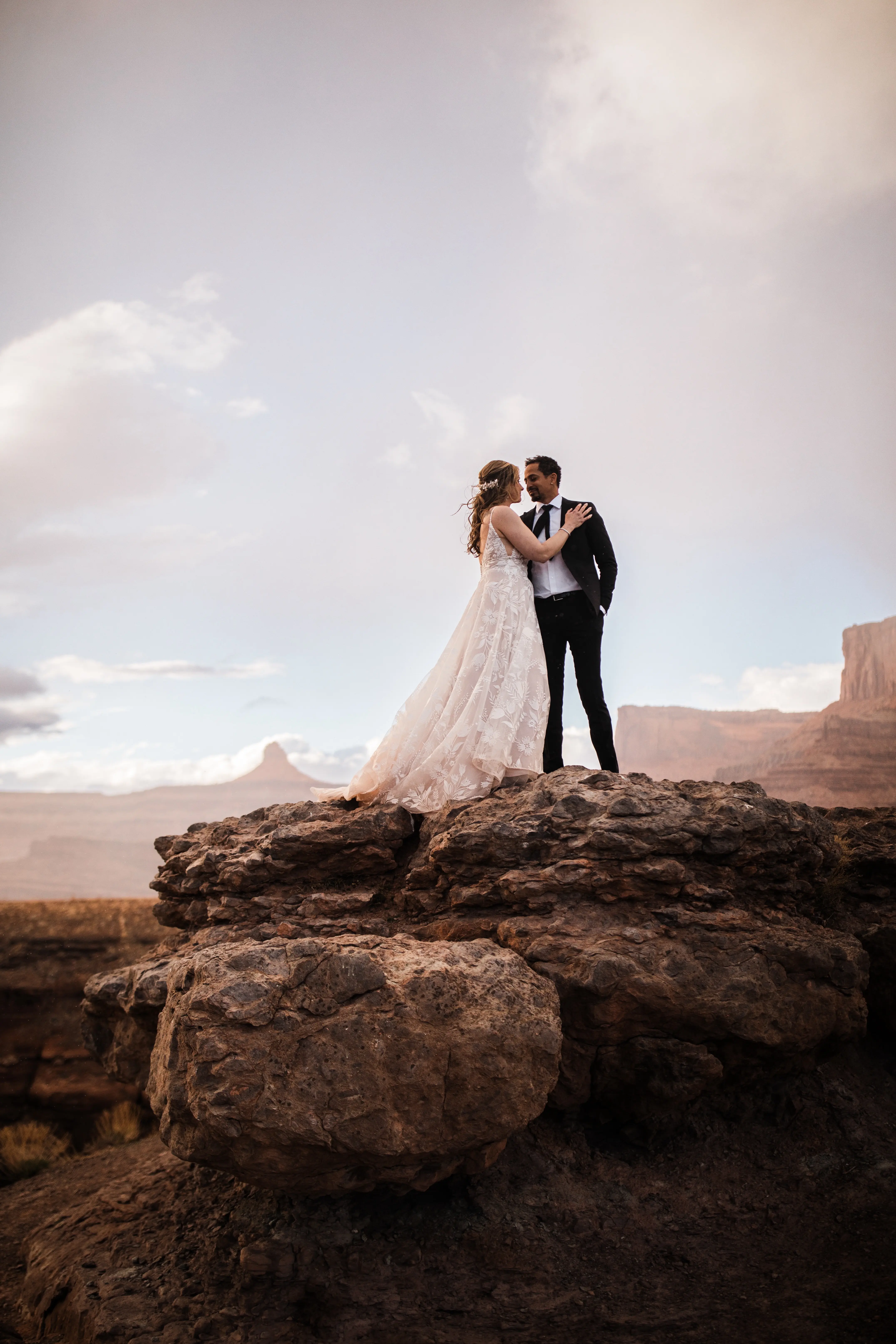 Groom With Bride Wearing A White A Line Wedding Dress Named Keisha By Maggie Sottero On Red Rocks In Desert