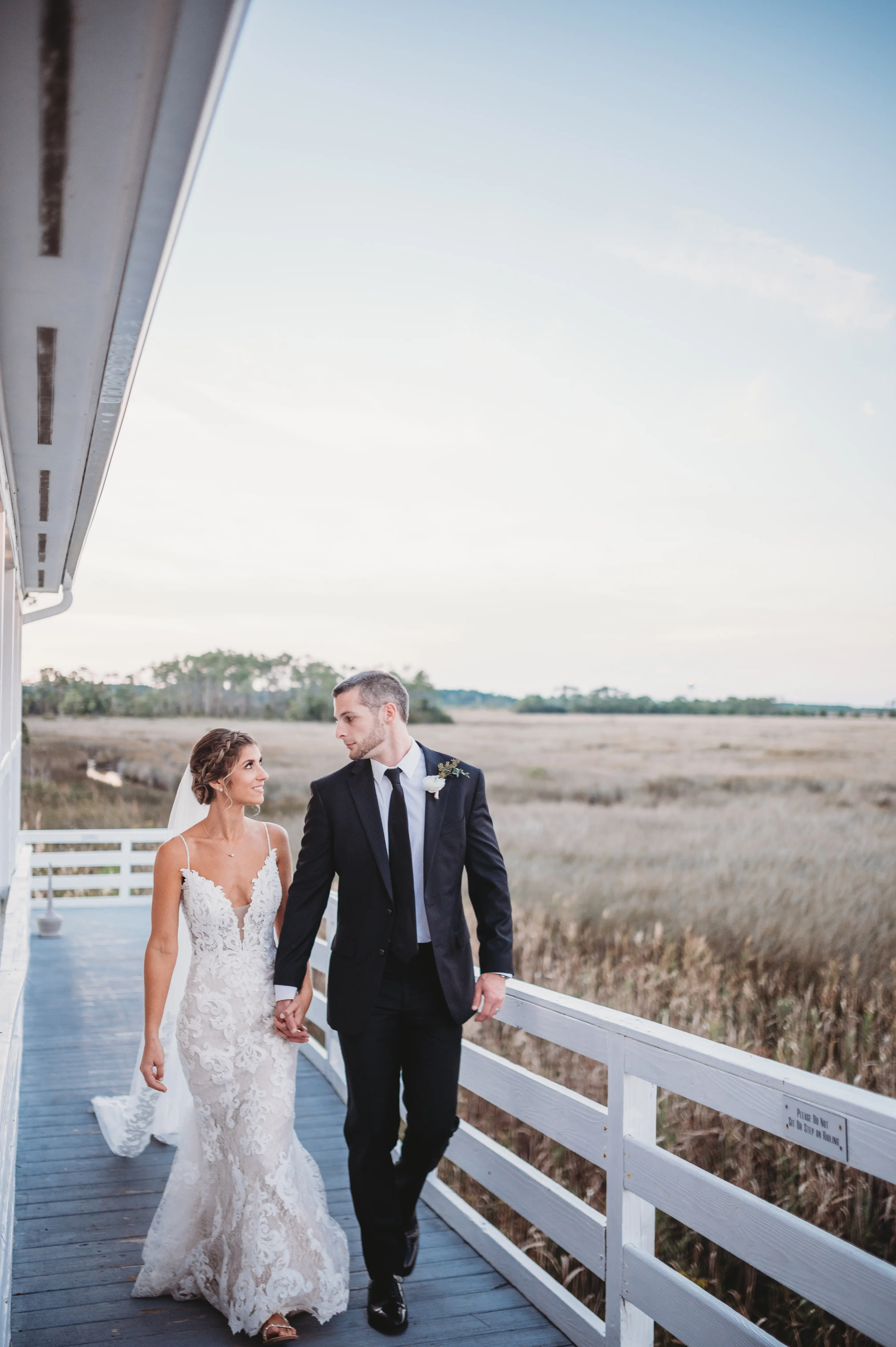 Groom Holding Hands with Bride in Mermaid Wedding Dress with Shimmering Lace Motifs and Illusion Plunging Sweetheart Neckline Called Tuscany by Maggie Sottero