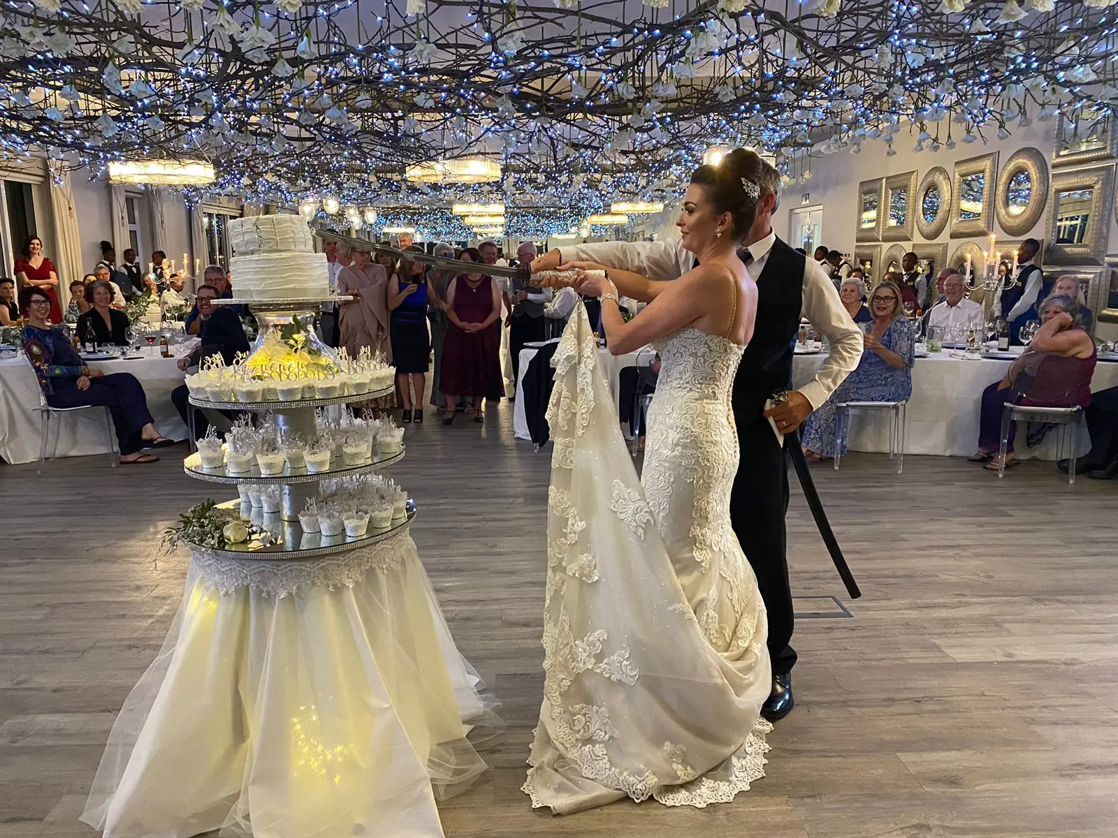 Bride In Lace Fit And Flare Wedding Dress Called Fiona By Maggie Sottero Cutting Cake With Groom