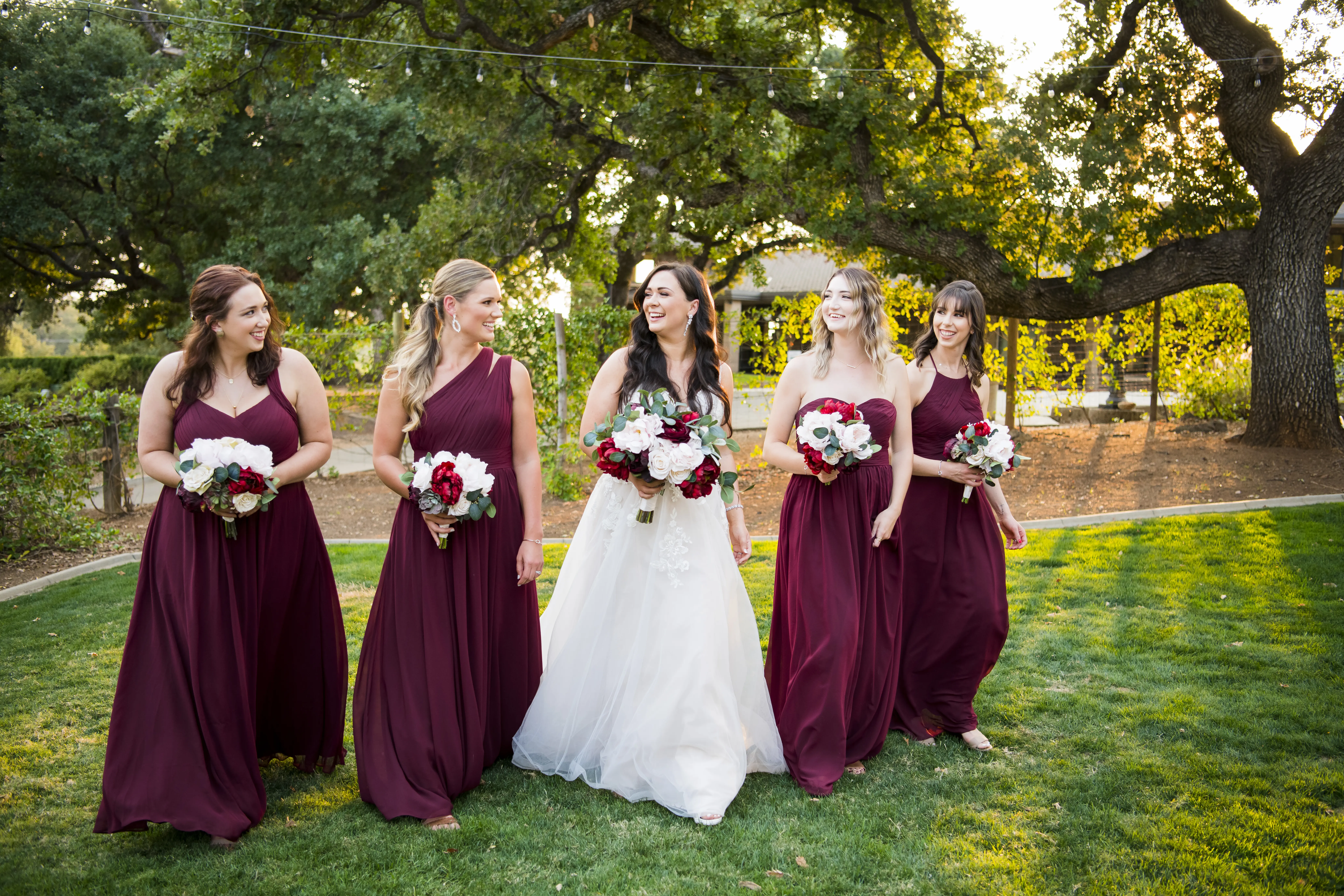 Bride wearing Princess Wedding Gown called Stevie by Maggie Sottero with her bridesmaids wearing maroon gowns