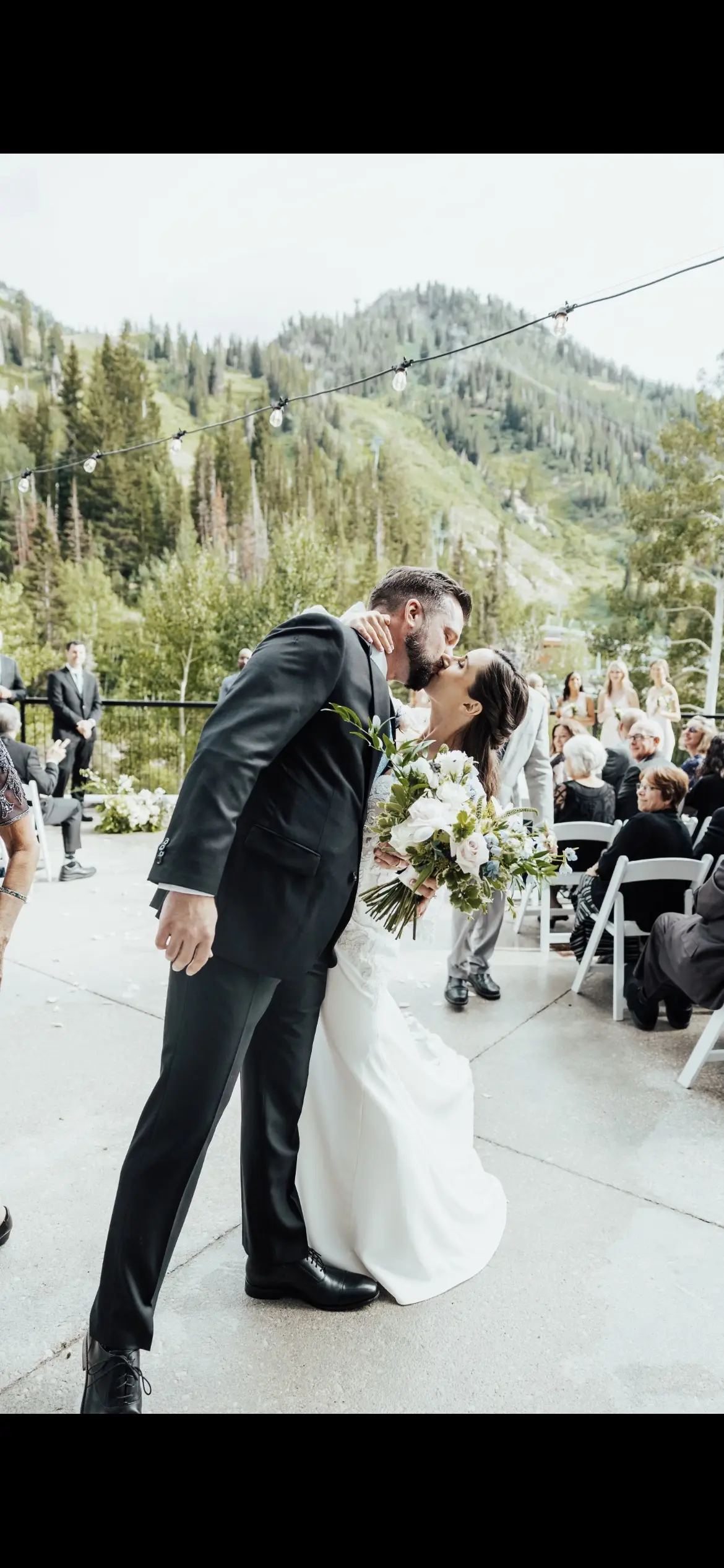 Bride Wearing Long Sleeve Lace Mermaid Wedding Dress Kissing Groom Outdoors.