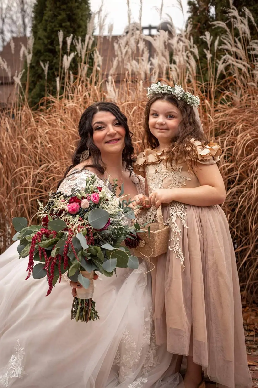 Bride with her flower girl smiling.