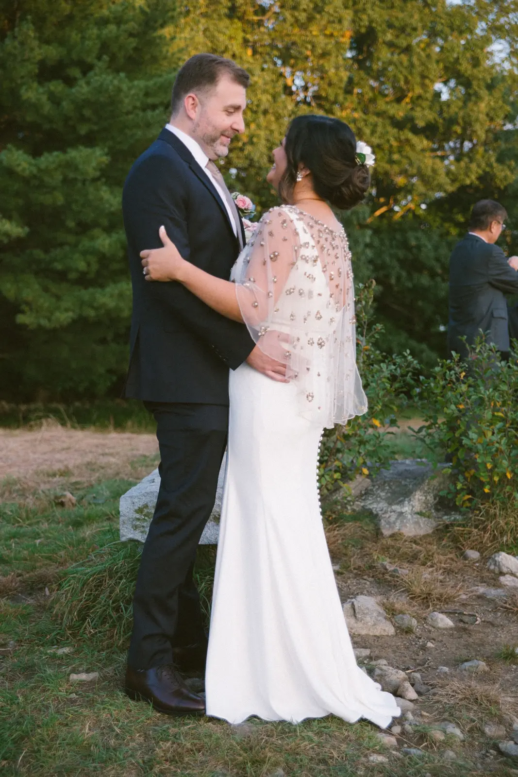 Groom and Bride Wearing Minimalist Crepe Fit-and-Flare Wedding Dress Called Fernanda by Maggie Sottero