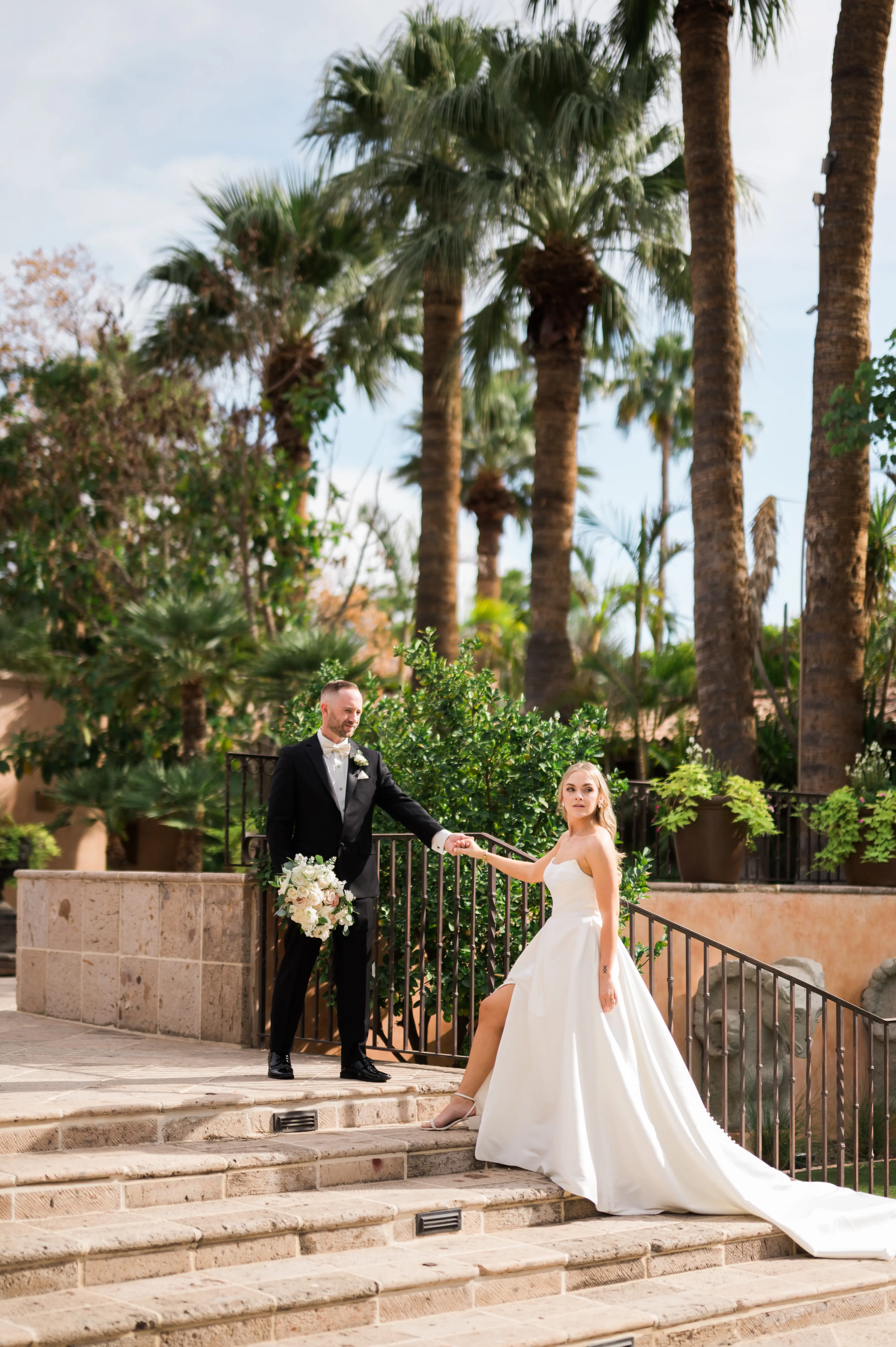 Bride wearing Aspen wedding dress by Sottero and Midgley walking up stairs with groom
