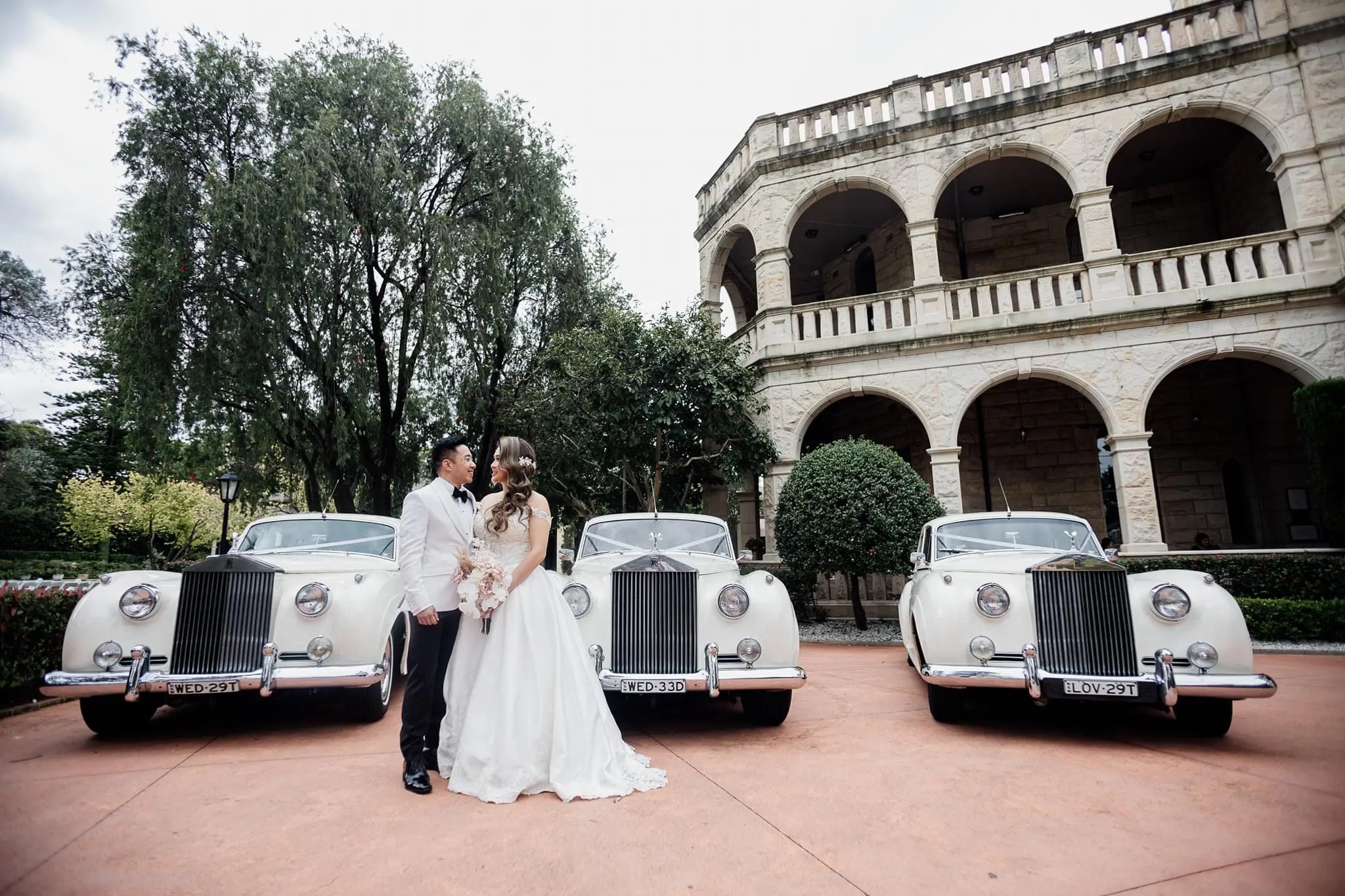 Bride Wearing Princess Ballgown Wedding Dress Called Kimora By Sottero And Midgley With Groom And 3 Vintage Cars