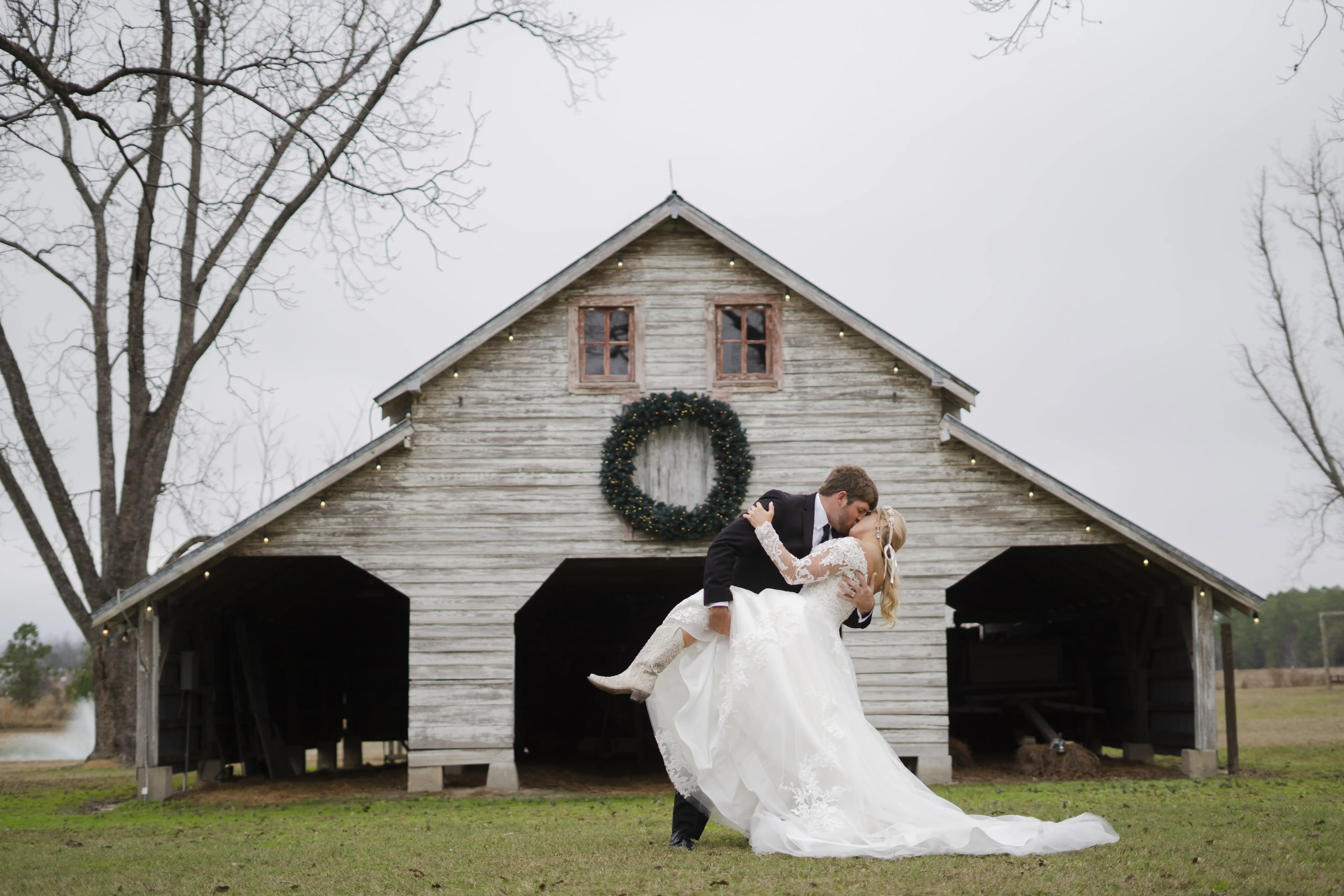 Bride In Off The Shoulder Lace Wedding Dress Called Tiffany By Maggie Sottero With Groom And Cowboy Boots