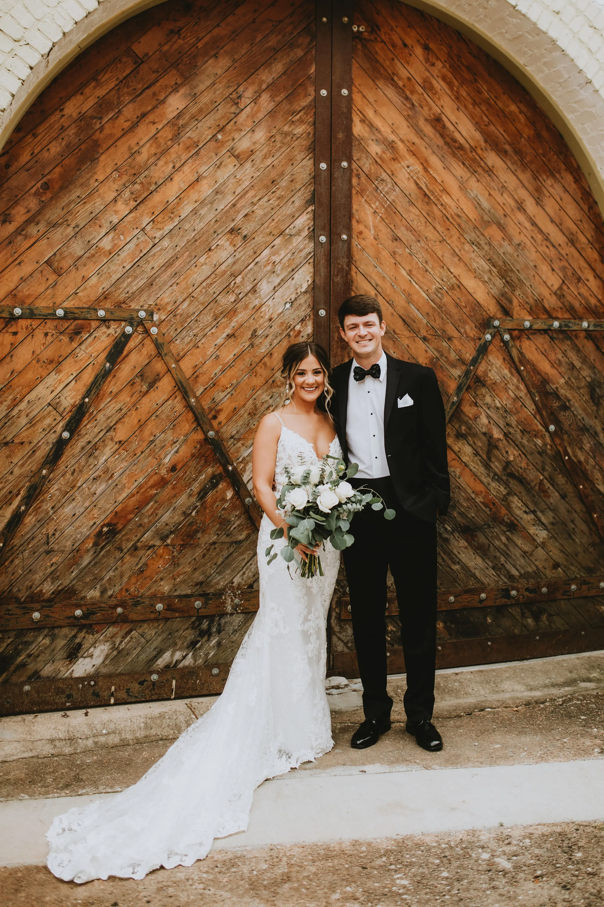 Bride with groom in romantic lace sheath wedding dress