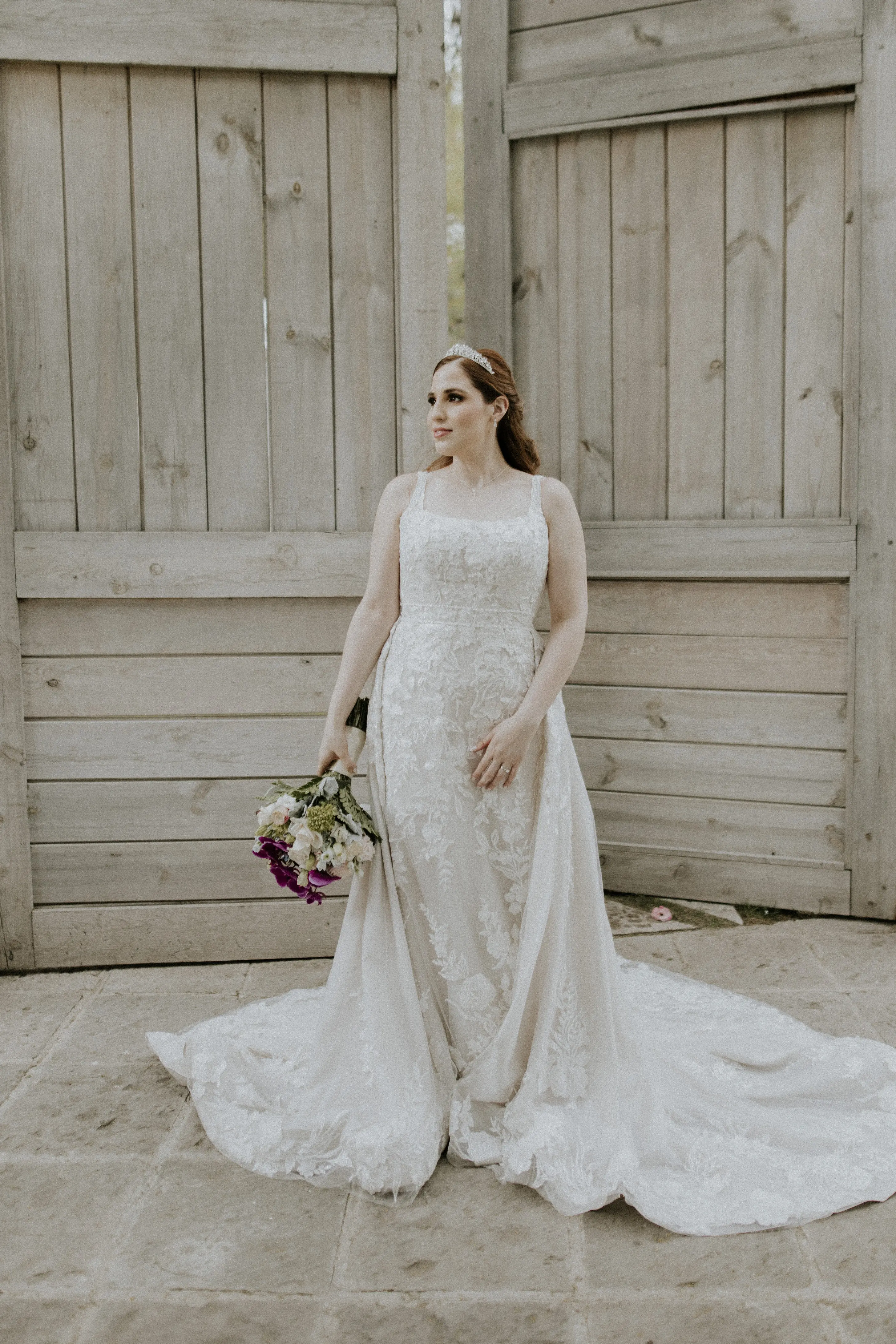 Bride Wearing Lace Wedding Dress Called Albany By Maggie Sottero Next To A Wooden Door