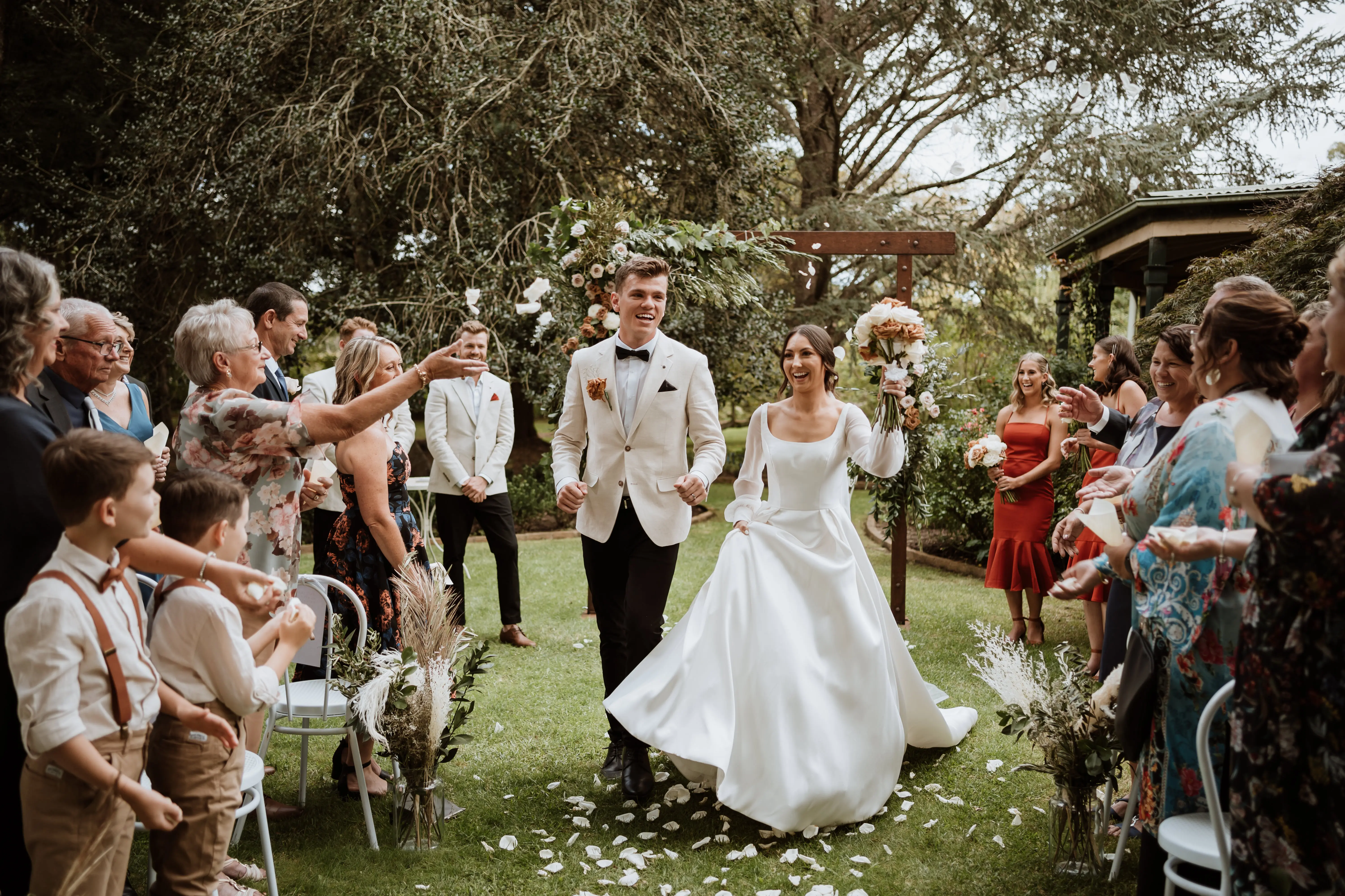 Newlyweds just married with guests throwing confetti.