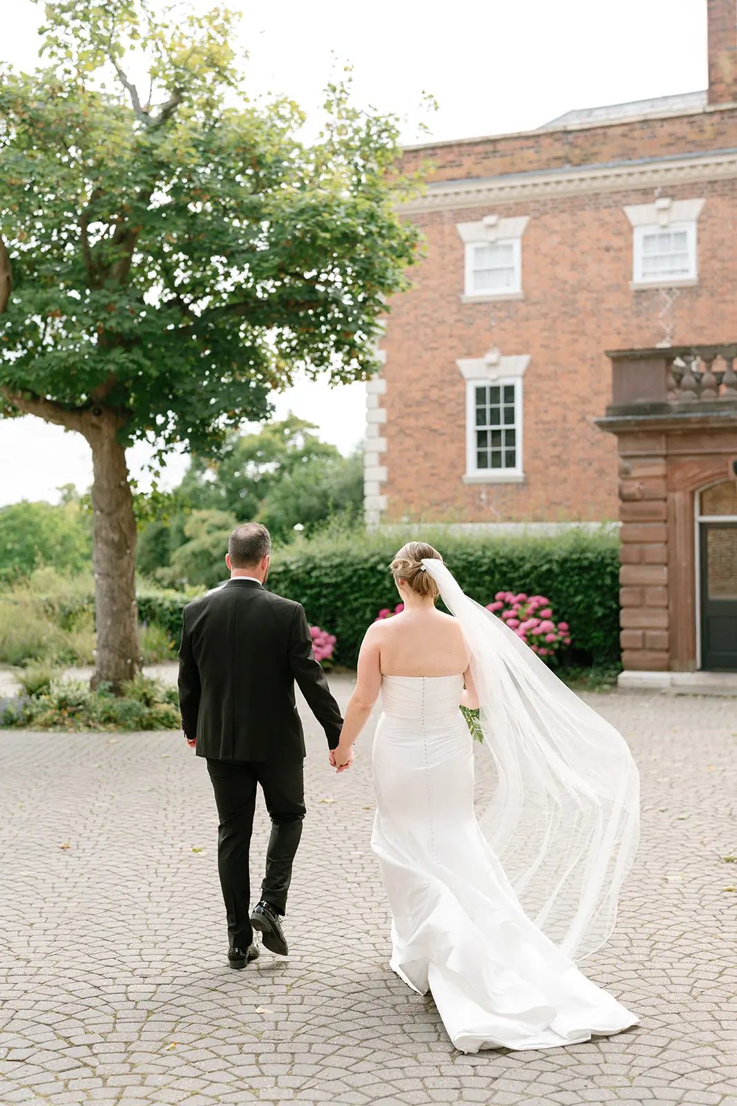 Bride Wearing Modern Wedding Dress Called Marilyn By Sottero And Midgley Walking With Groom