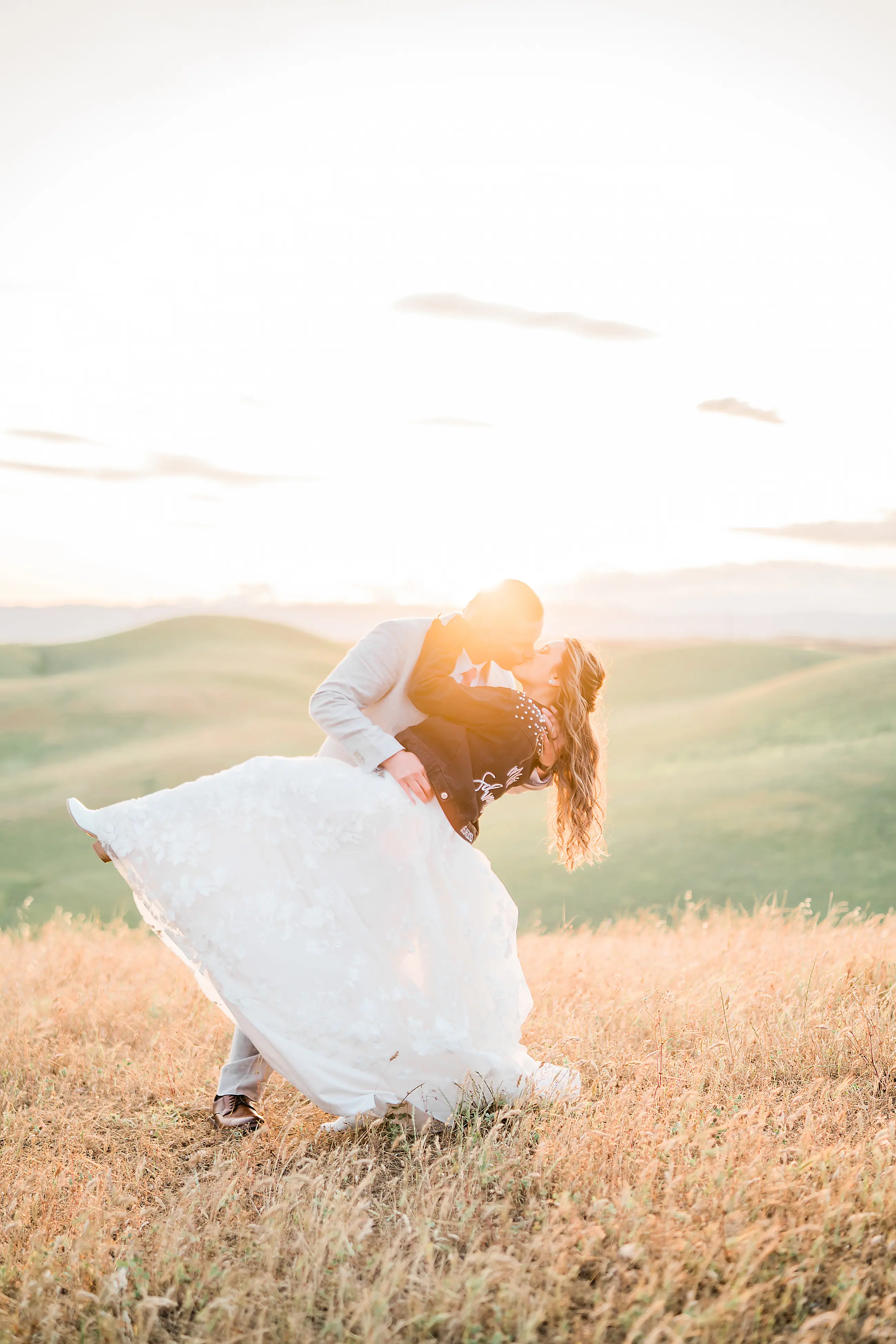 Groom Dips Bride Wearing Whimsical Wedding Gown Winter by Maggie Sottero and Leather Jacket