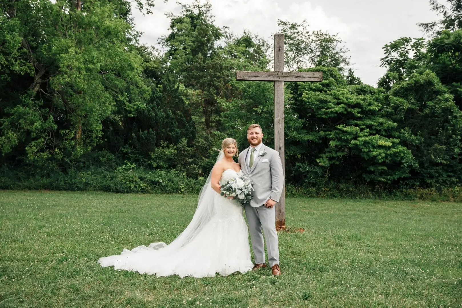 Bride with groom wearing glamorous plus size mermaid wedding dress