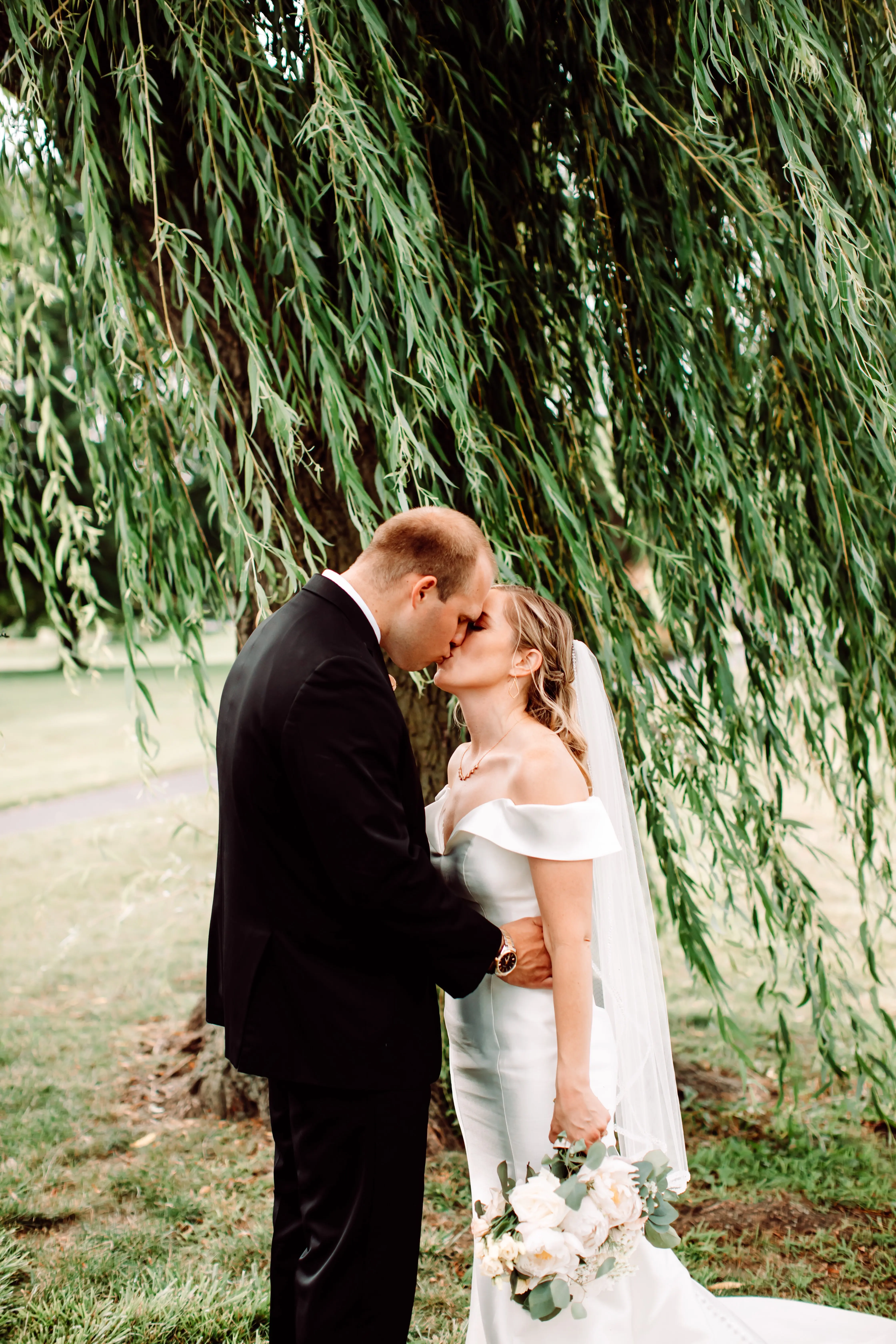 Groom kissing bride who is wearing wedding dress called Josie.