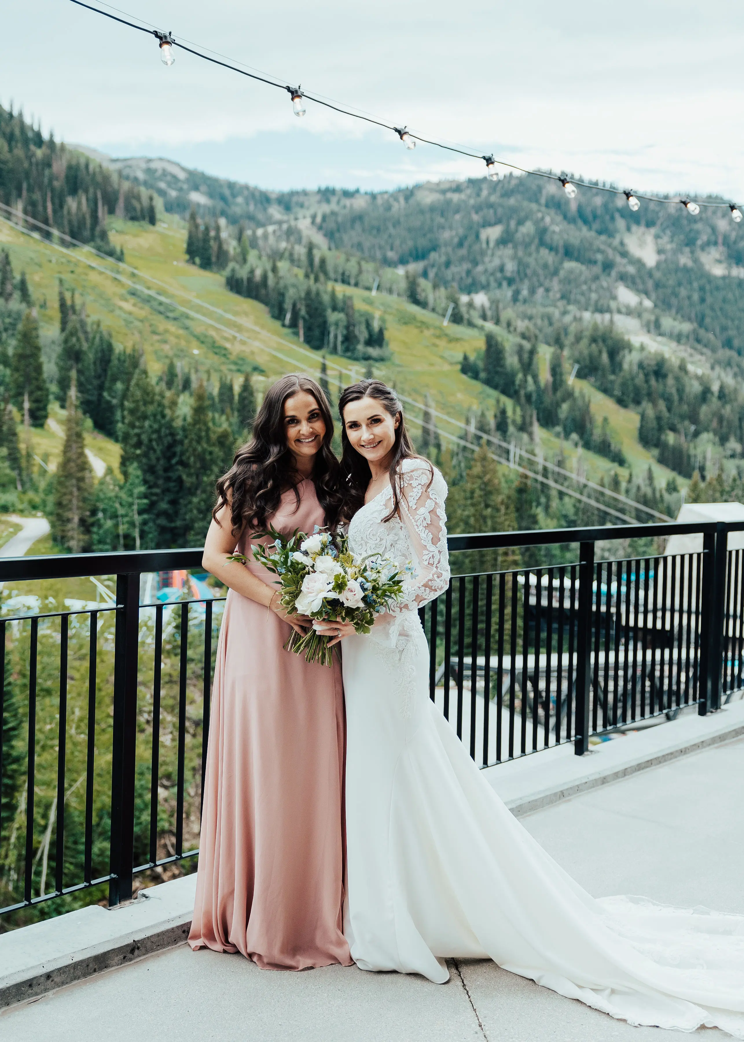 Bride Wearing Long Sleeve Lace Mermaid Wedding Dress with Bridesmaid Outdoors.