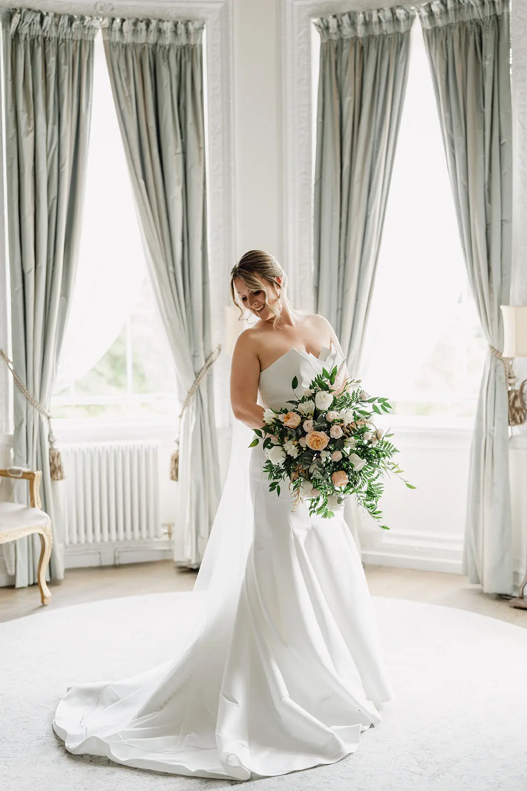 Bride Wearing Modern Wedding Dress Called Marilyn By Sottero And Midgley Holding Pastel Rose Bouquet