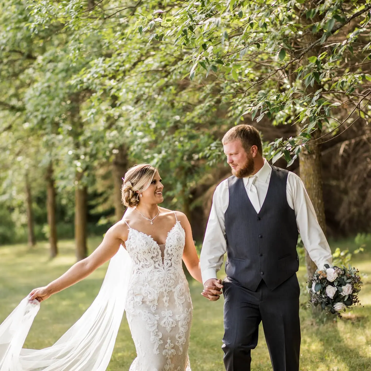 Bride with groom wearing romantic lace sheath wedding dress