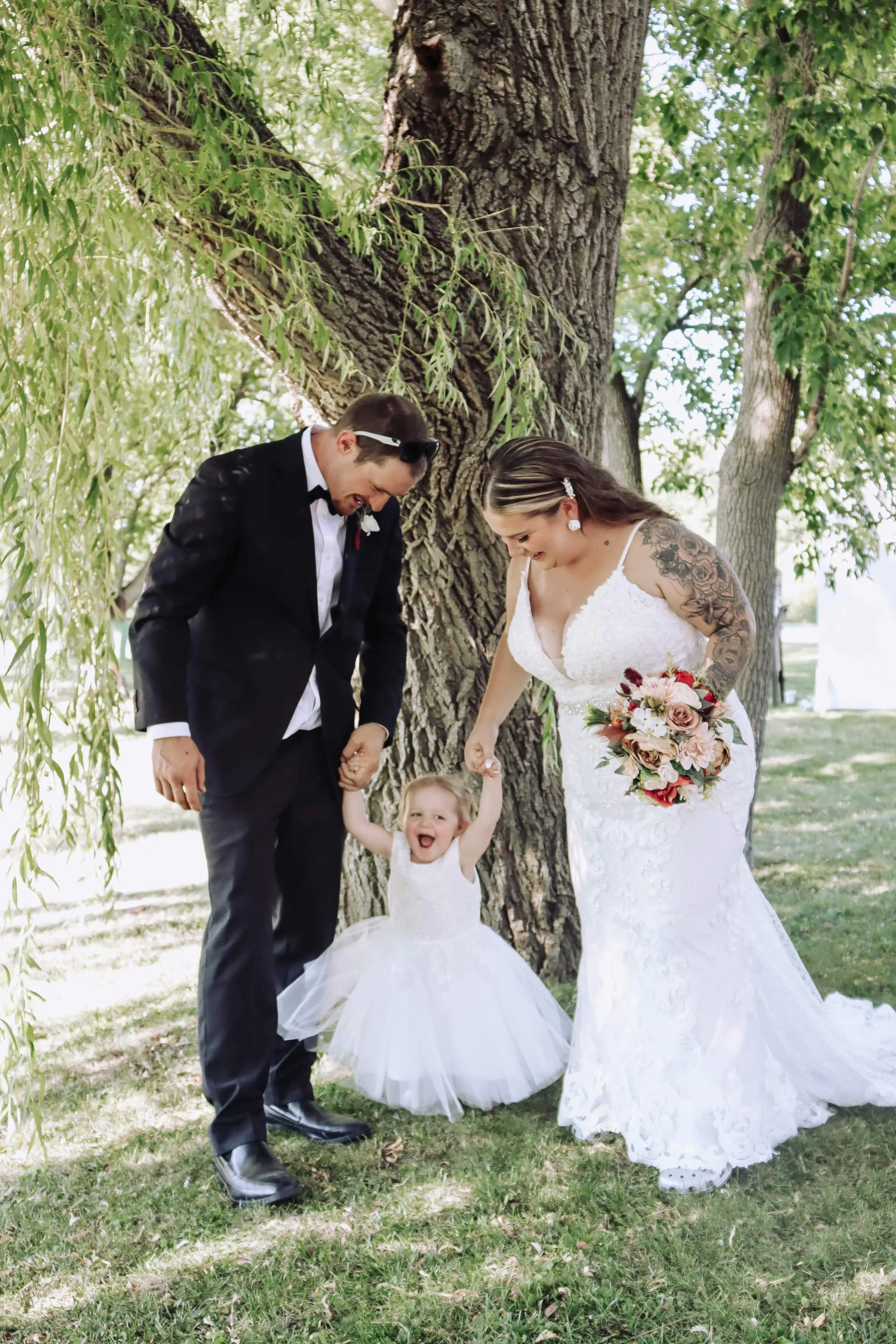 Bride Wearing Sheath Lace Wedding Dress With Beaded Belt Called Tuscany Lynette By Maggie Sottero With Groom And Happy Little Girl