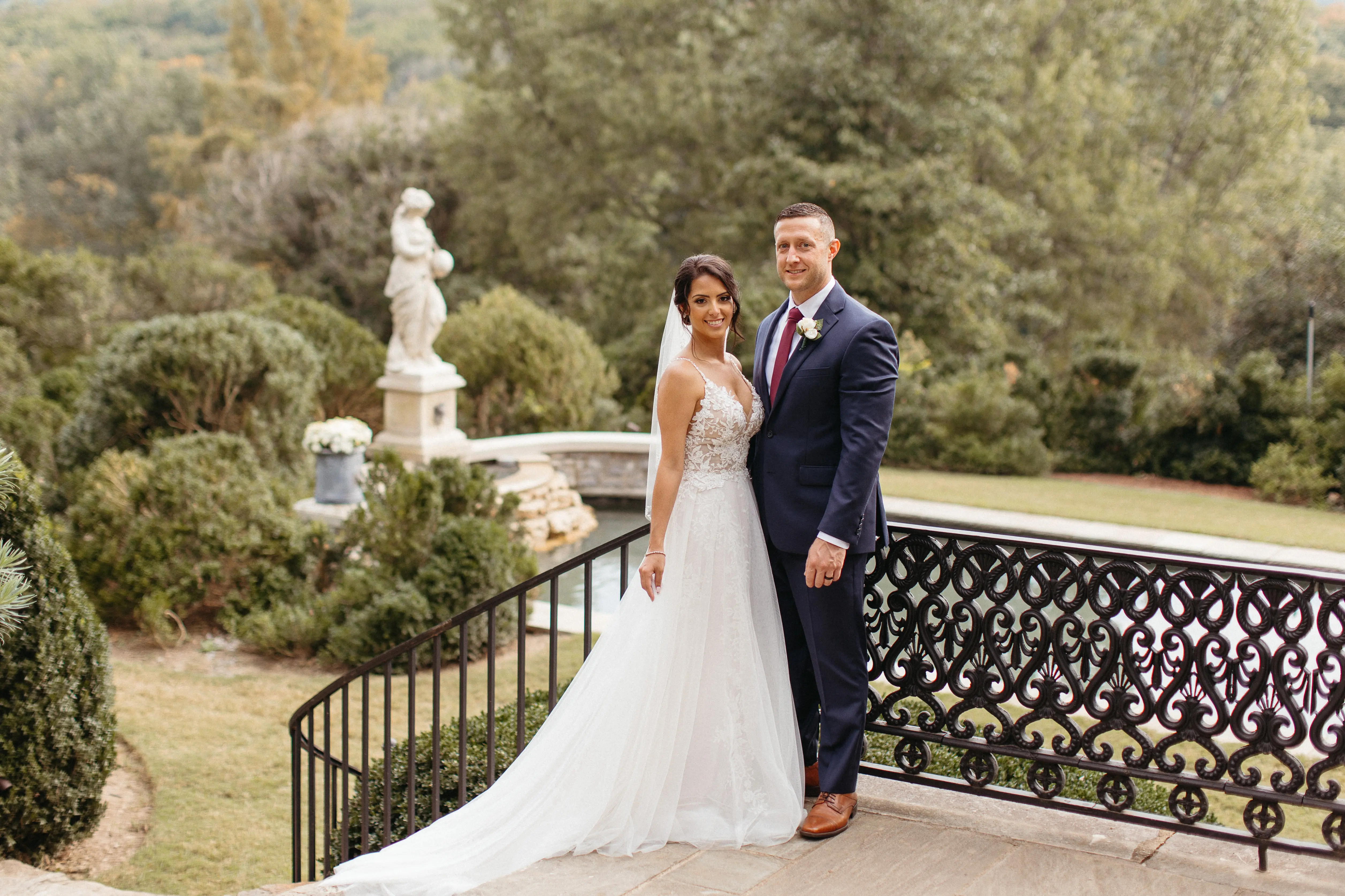 Bride wearing wedding dress called Roanne Rose stood at top of stairs with her groom.