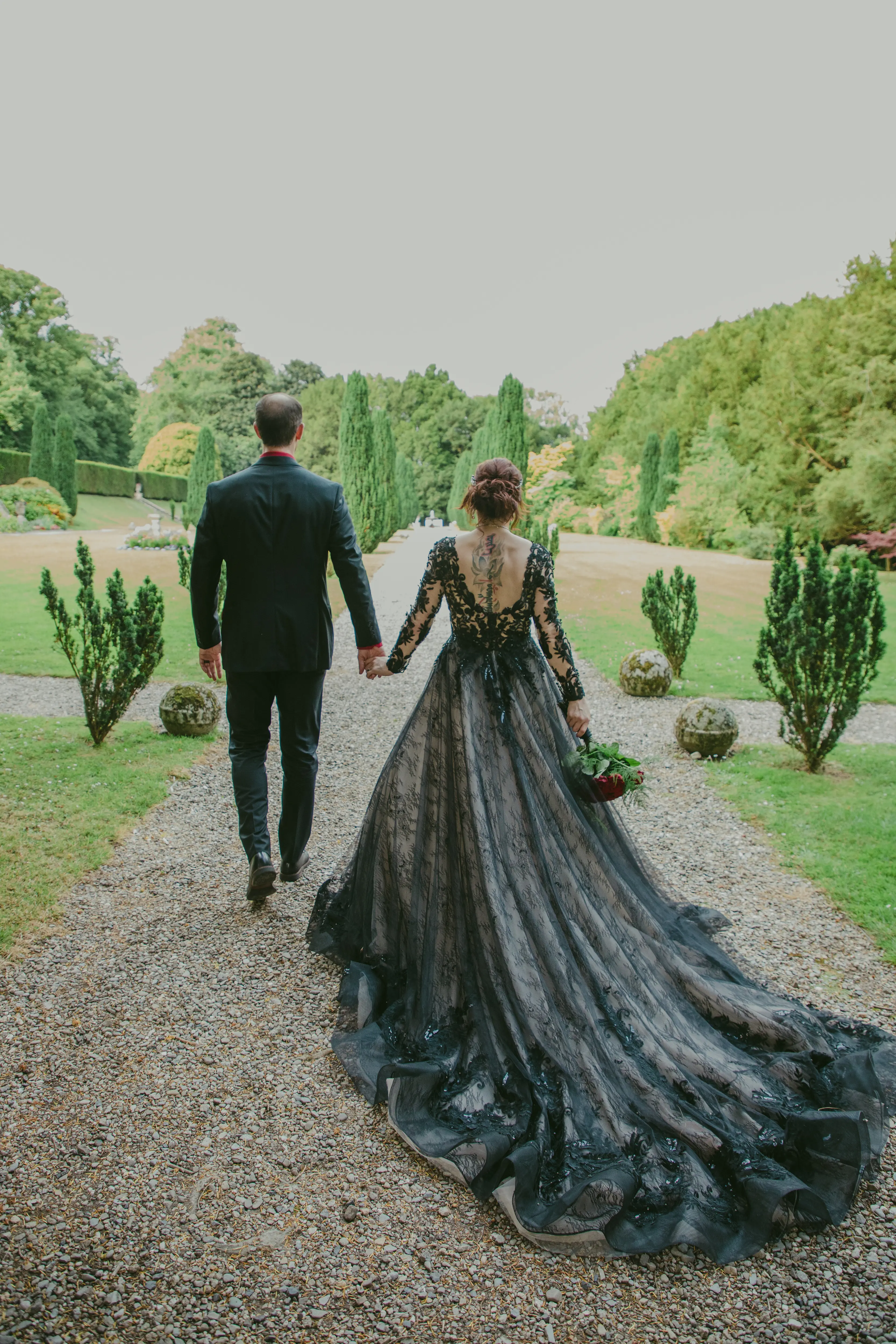 Bride wearing Zander wedding dress by Sottero and Midgley walking holding hands with her husband