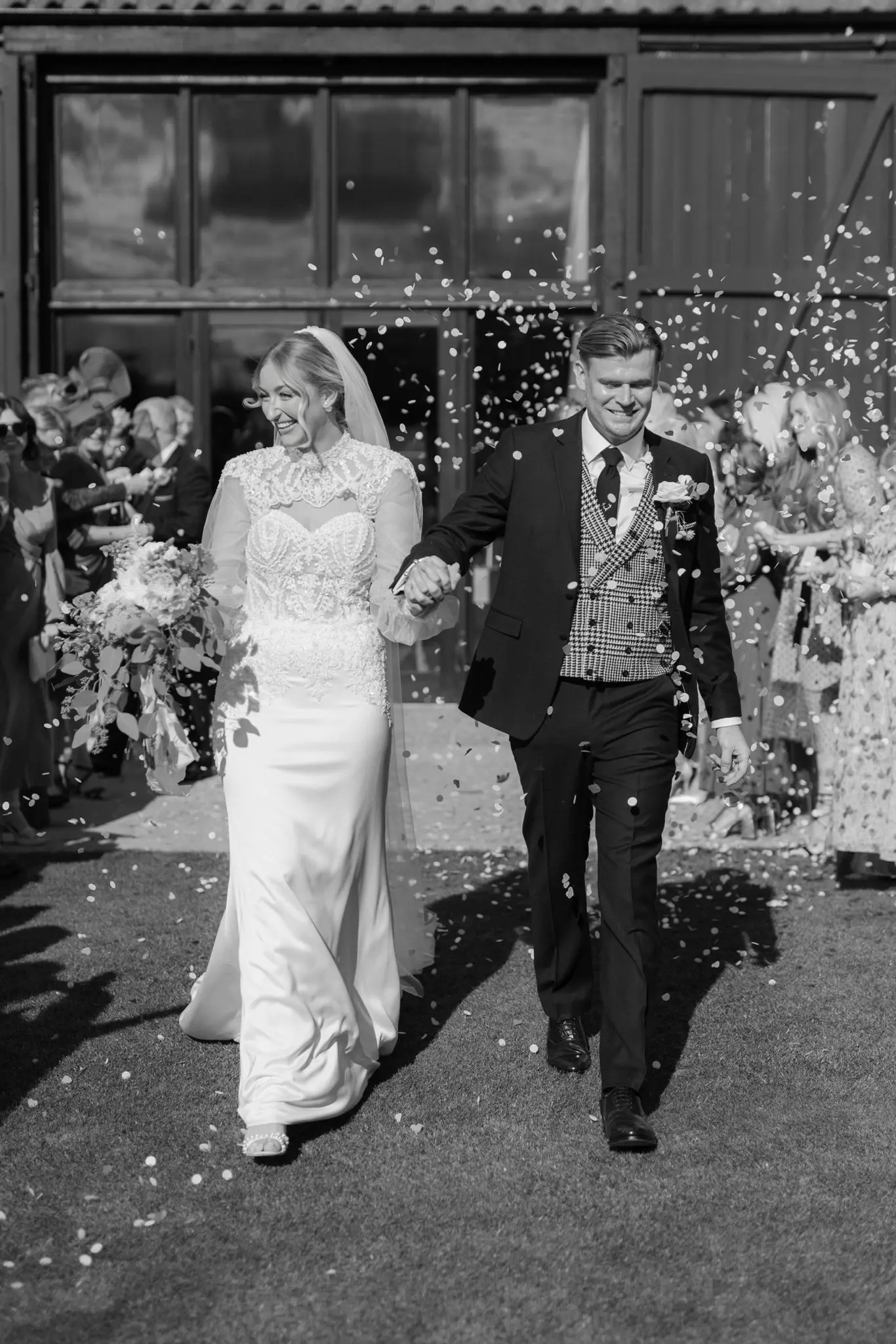 Bride wearing Yates wedding dress by Maggie Sottero with flower petals being thrown