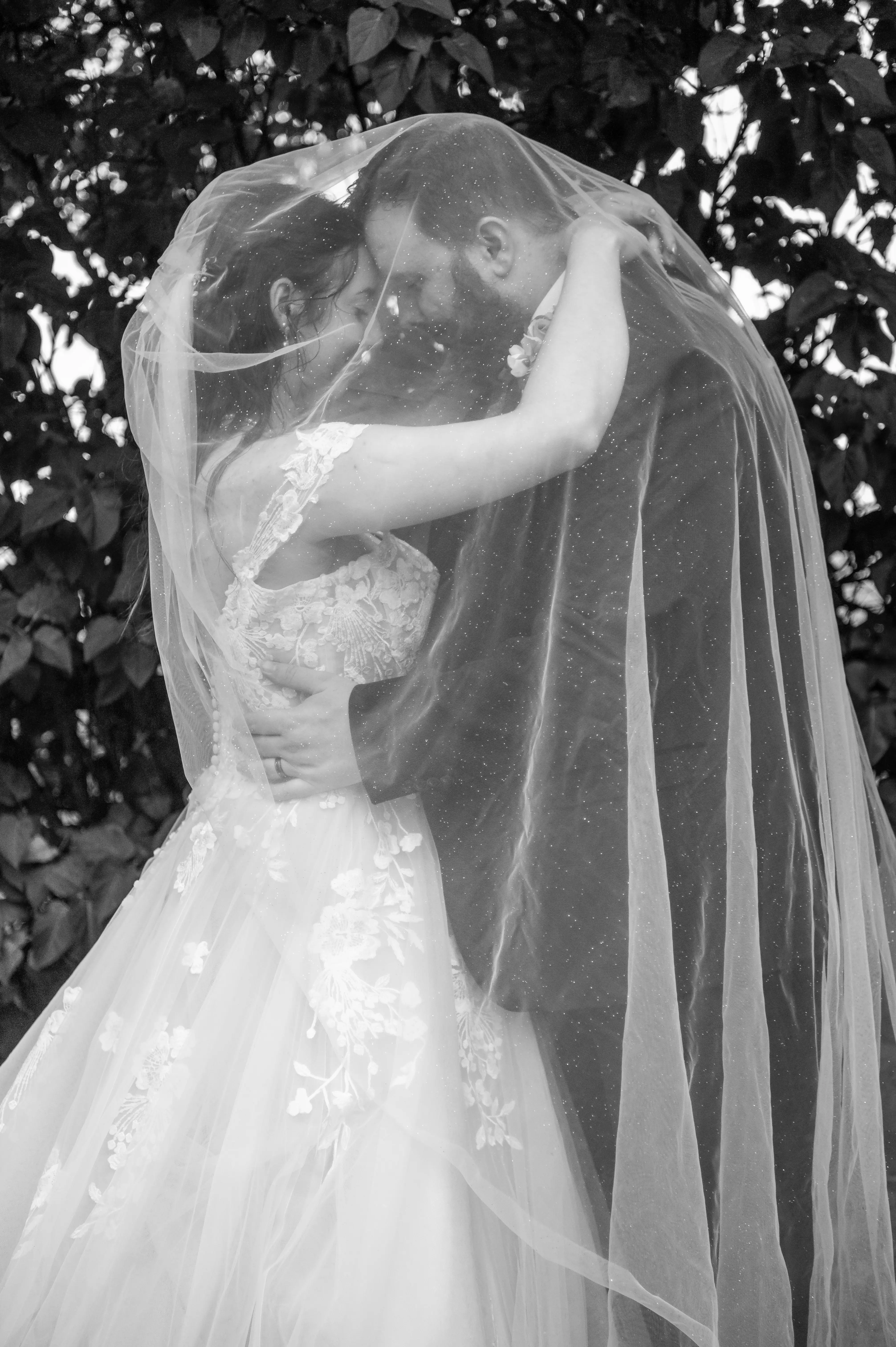 Bride wearing Harlem by Maggie Sottero embracing her husband under her veil