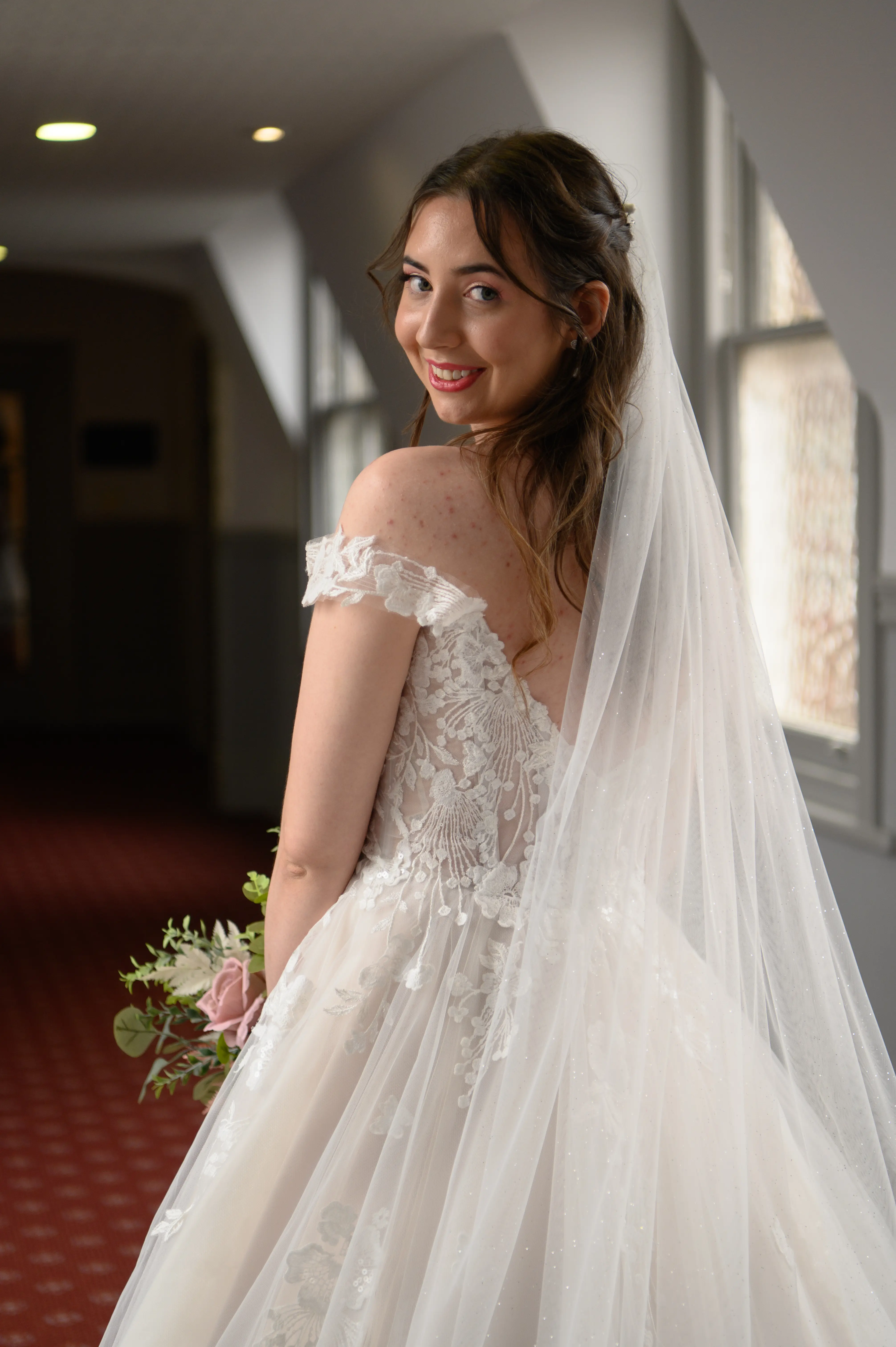 Bride wearing Harlem by Maggie Sottero smiling over her shoulder