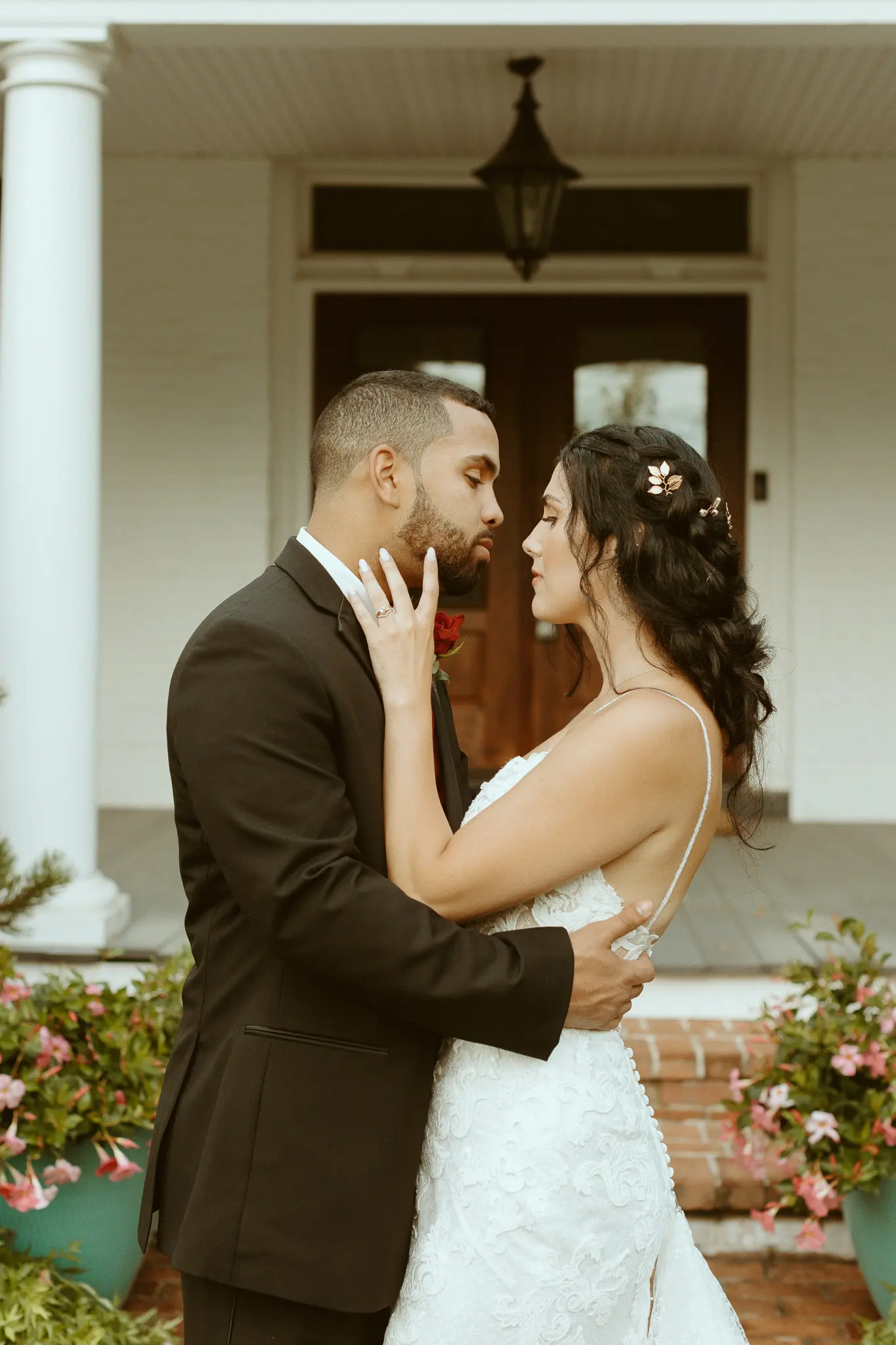 Bride with groom wearing lace sheath wedding dress.