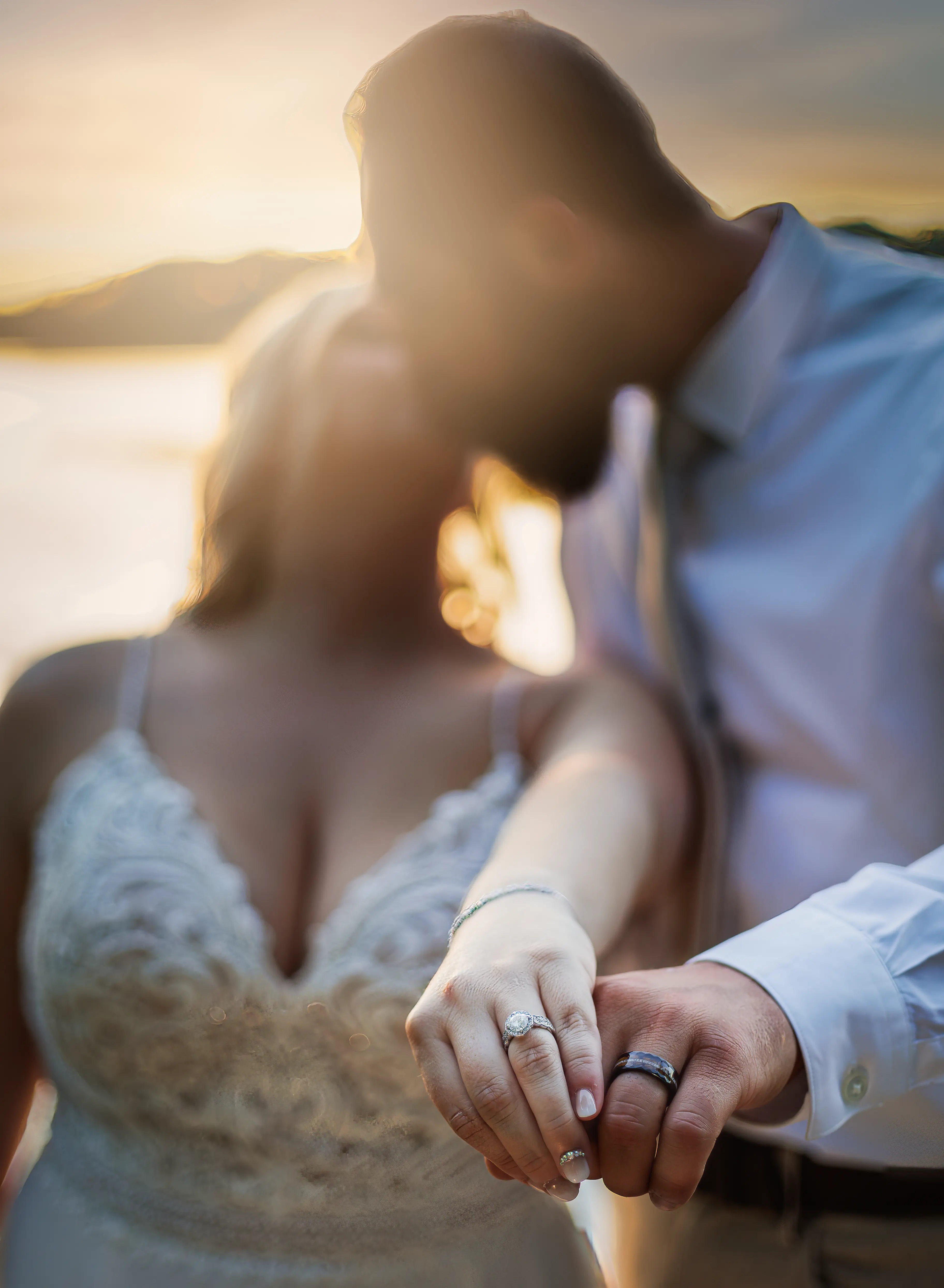 Bride Wearing Beaded Wedding Dress With Flowy Skirt Called Lorraine By Rebecca Ingram Kissing Groom And Showing Rings
