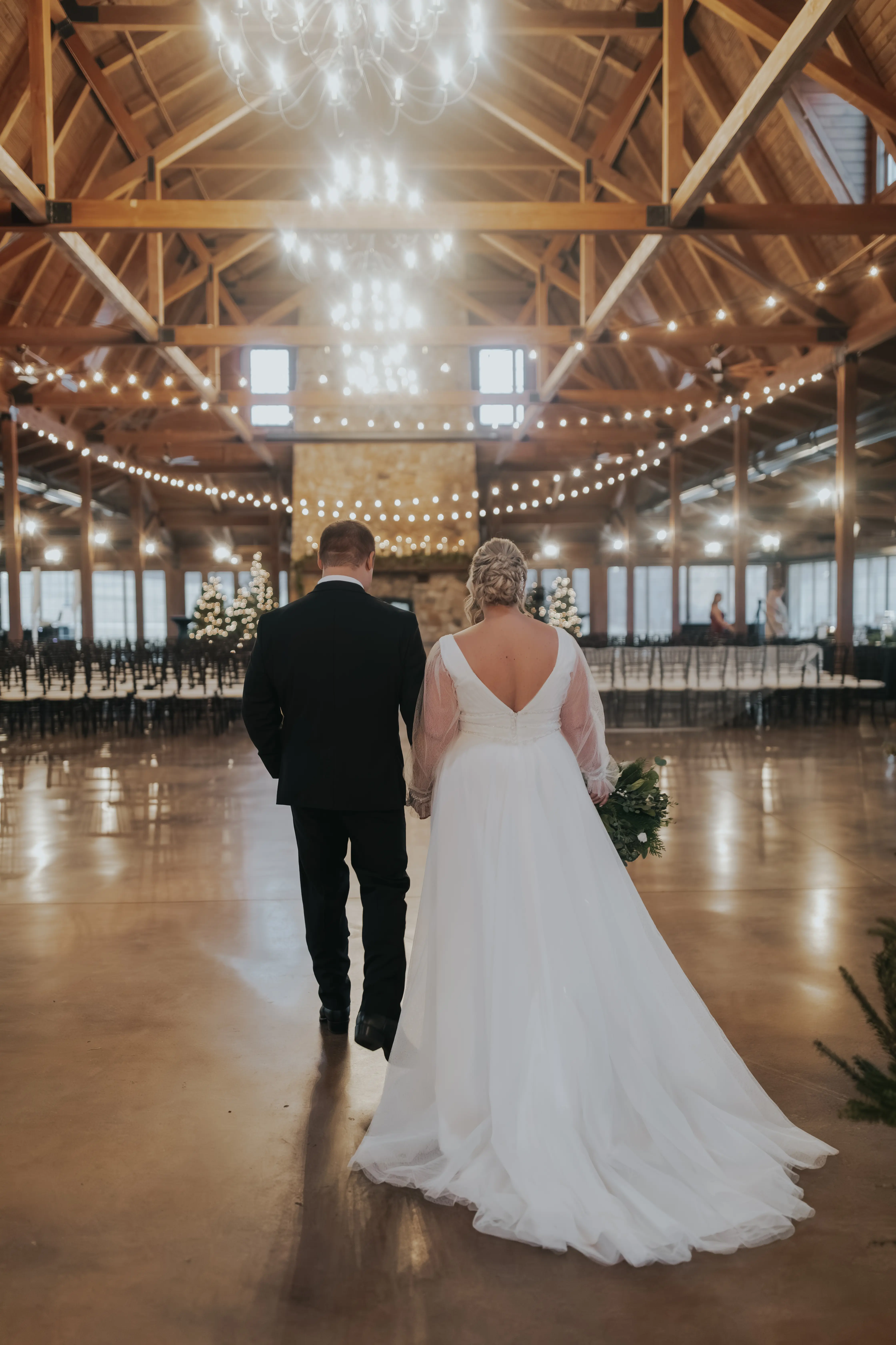 Bride wearing Joanne wedding dress by Rebecca Ingram holding hands with her husband