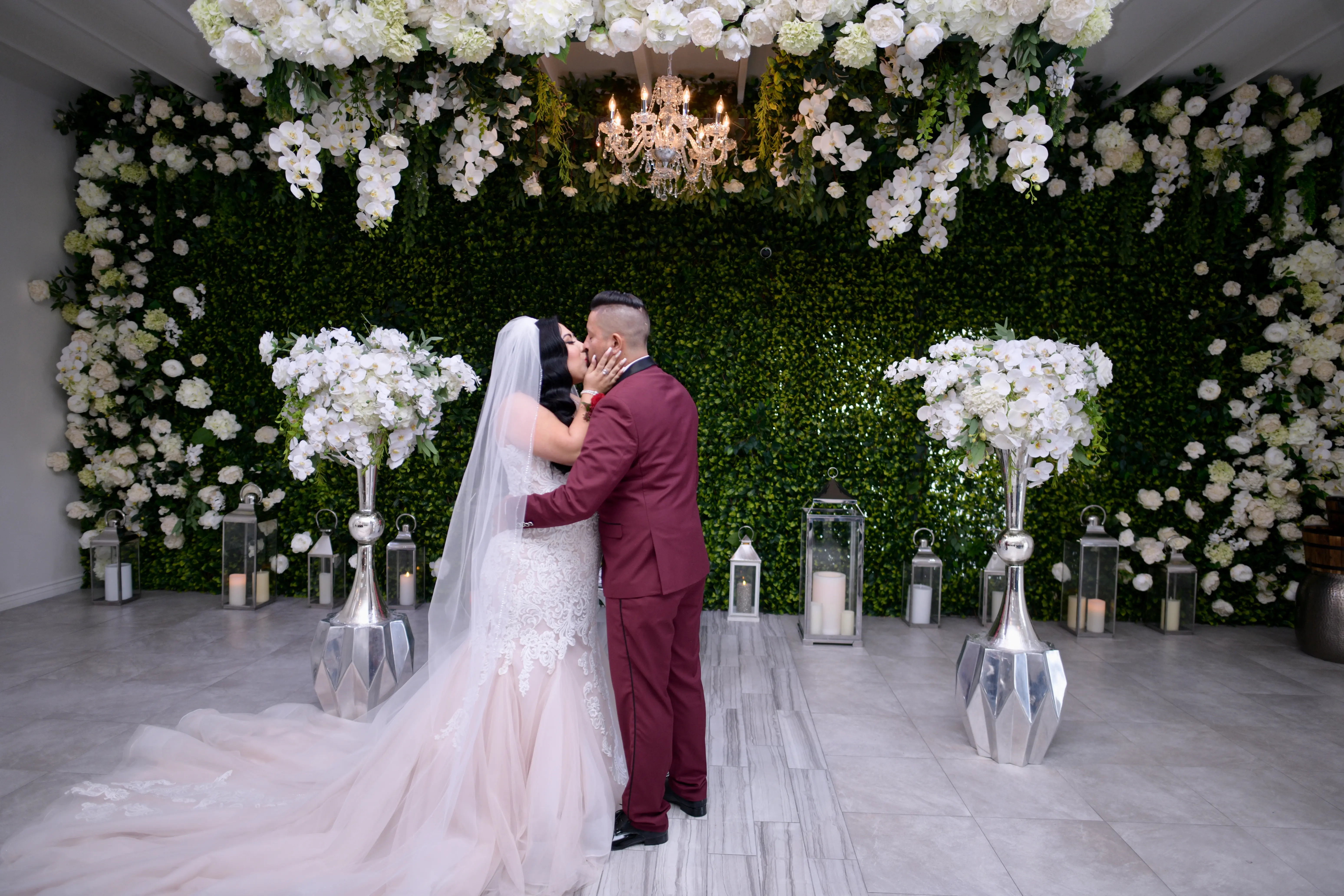 Bride and groom kissing surrounded with ivory florals.