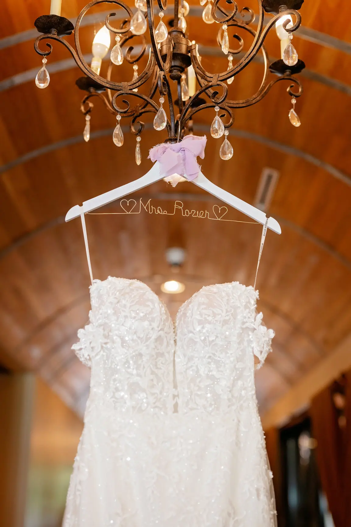 Lace Wedding Dress Called Lennon By Maggie Sottero Hanging From A Chandelier