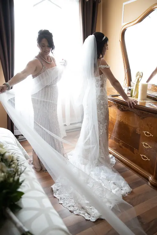 Bride Wearing Lace Sheath Wedding Dress Called Tuscany Lynette By Maggie Sottero Trying On Her Veil