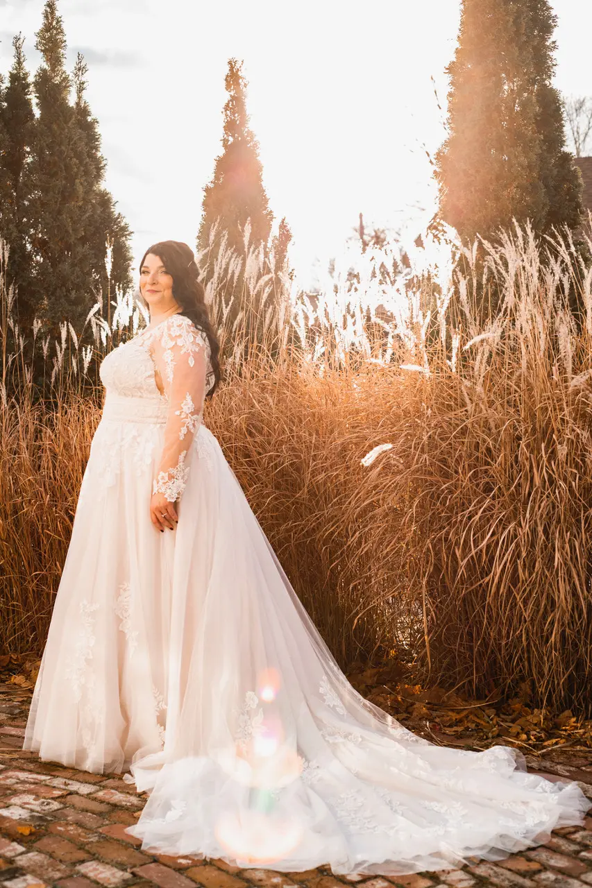 Bride glowing in sunshine wearing wedding dress called Raphael.