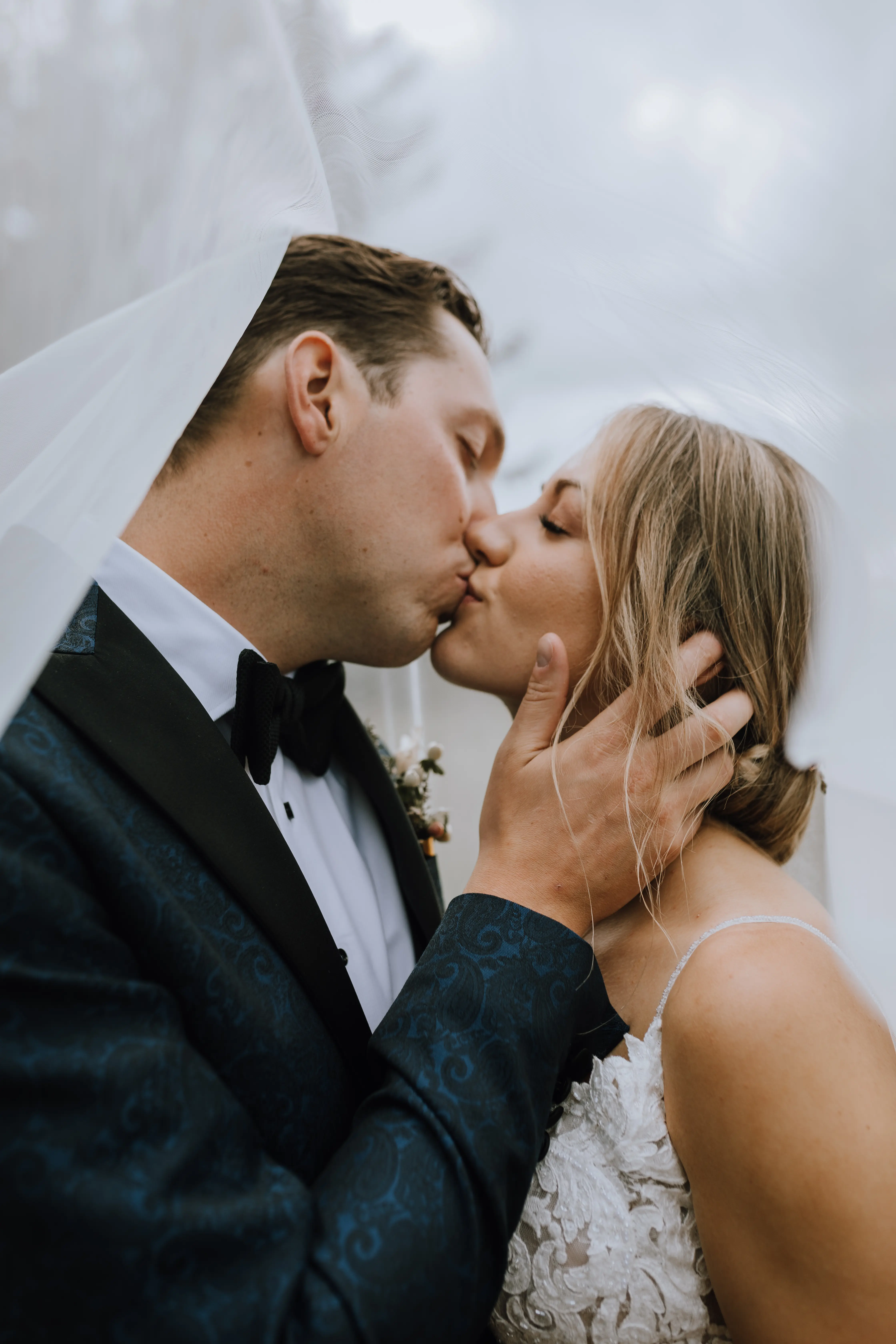 Bride with groom wearing a romantic lace sheath wedding dress.