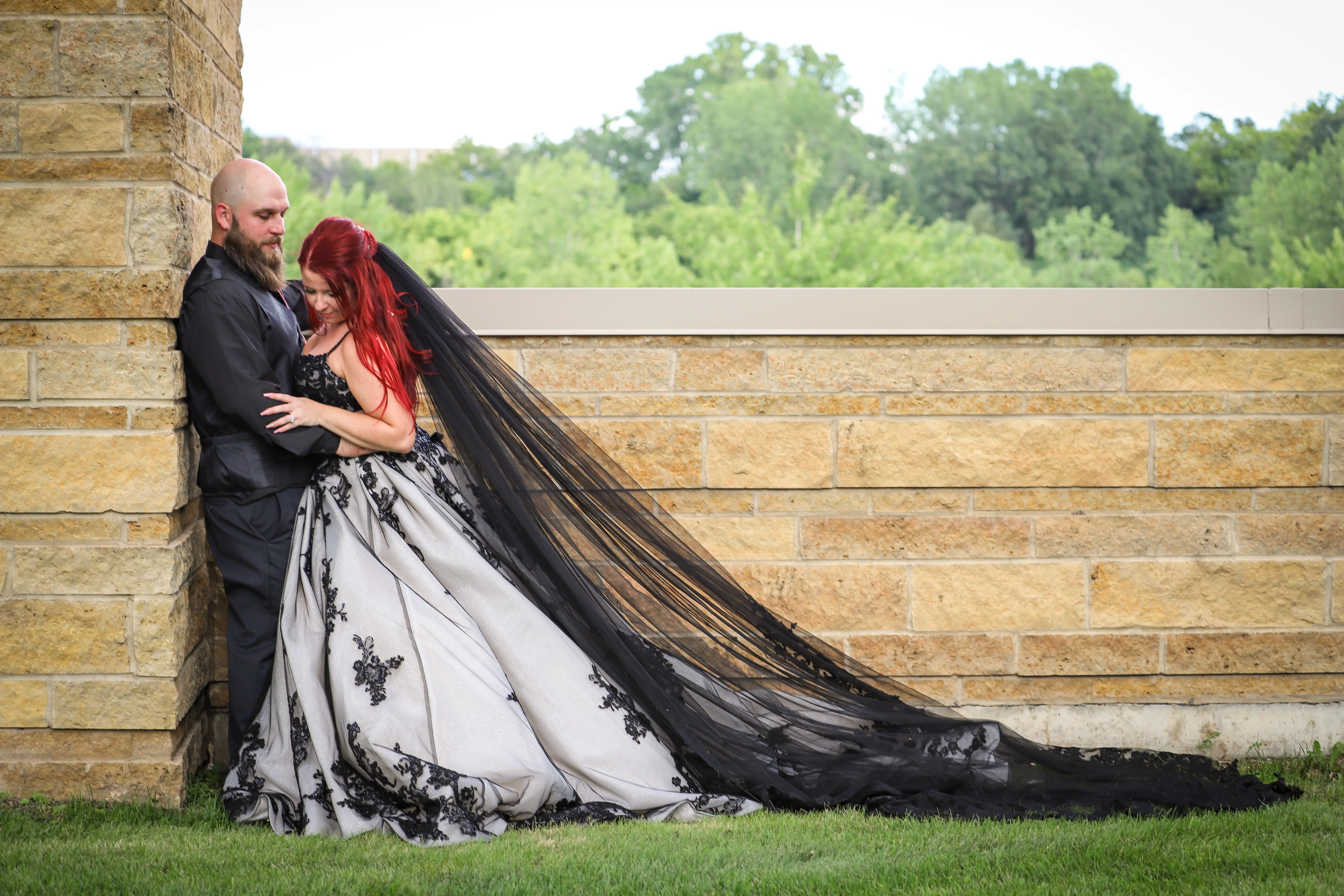 Bride And Groom Standing Together. Bride Wearing Royal-Inspired Ball Gown Wedding Dress In Black Lace Called Norvinia By Sottero And Midgley