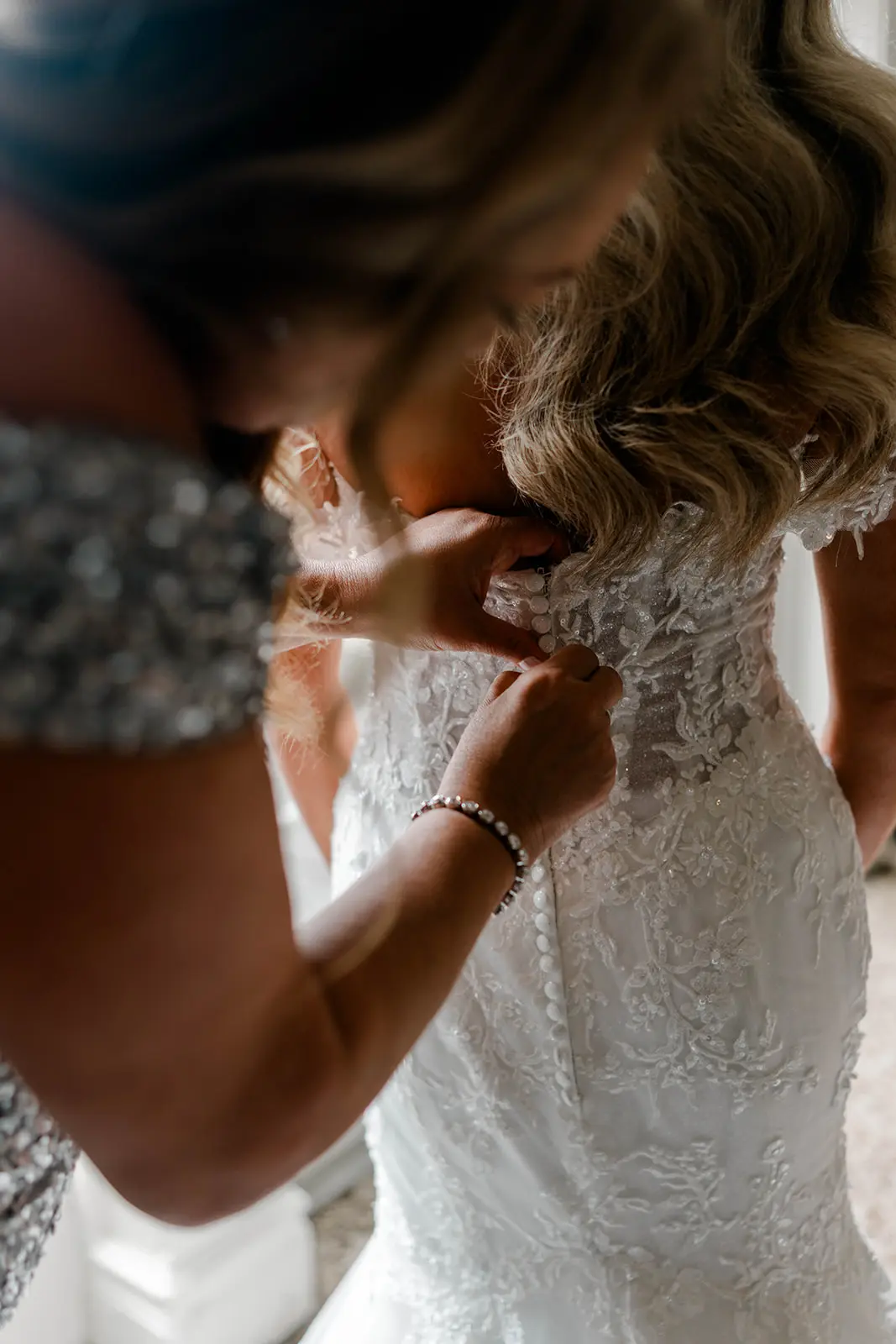 Bride wearing Lennon by Maggie Sottero being buttoned up