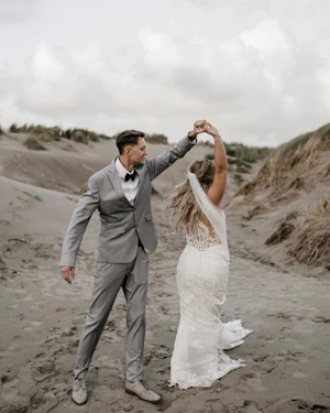 Bride Wearing Illusion Lace Back Wedding Dress Called Hamilton By Sottero And Midgley Dancing On The Beach With Groom