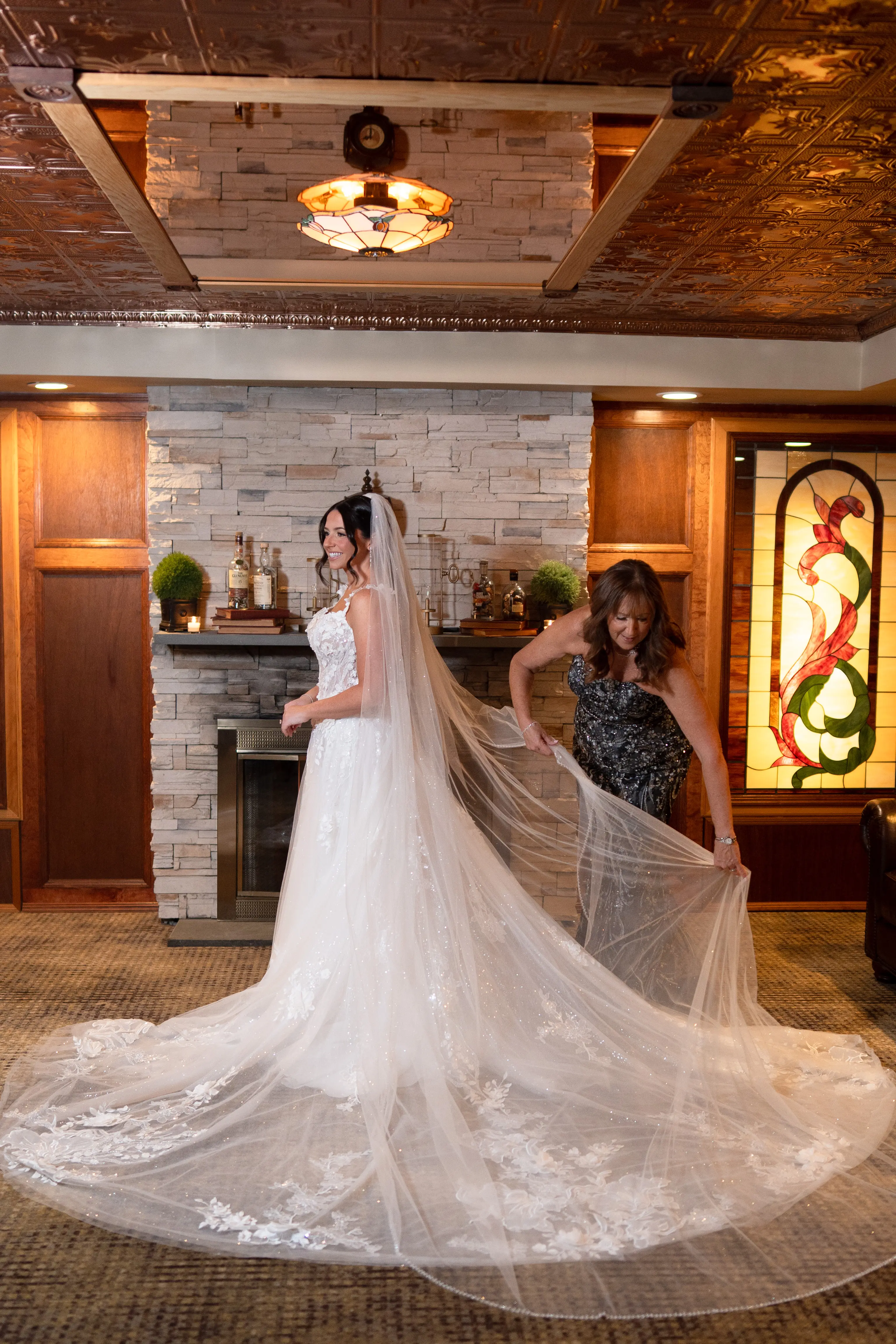 Bride Wearing Wicklow Wedding Dress By Sottero And Midgley While Her Mother Fixes Her Train