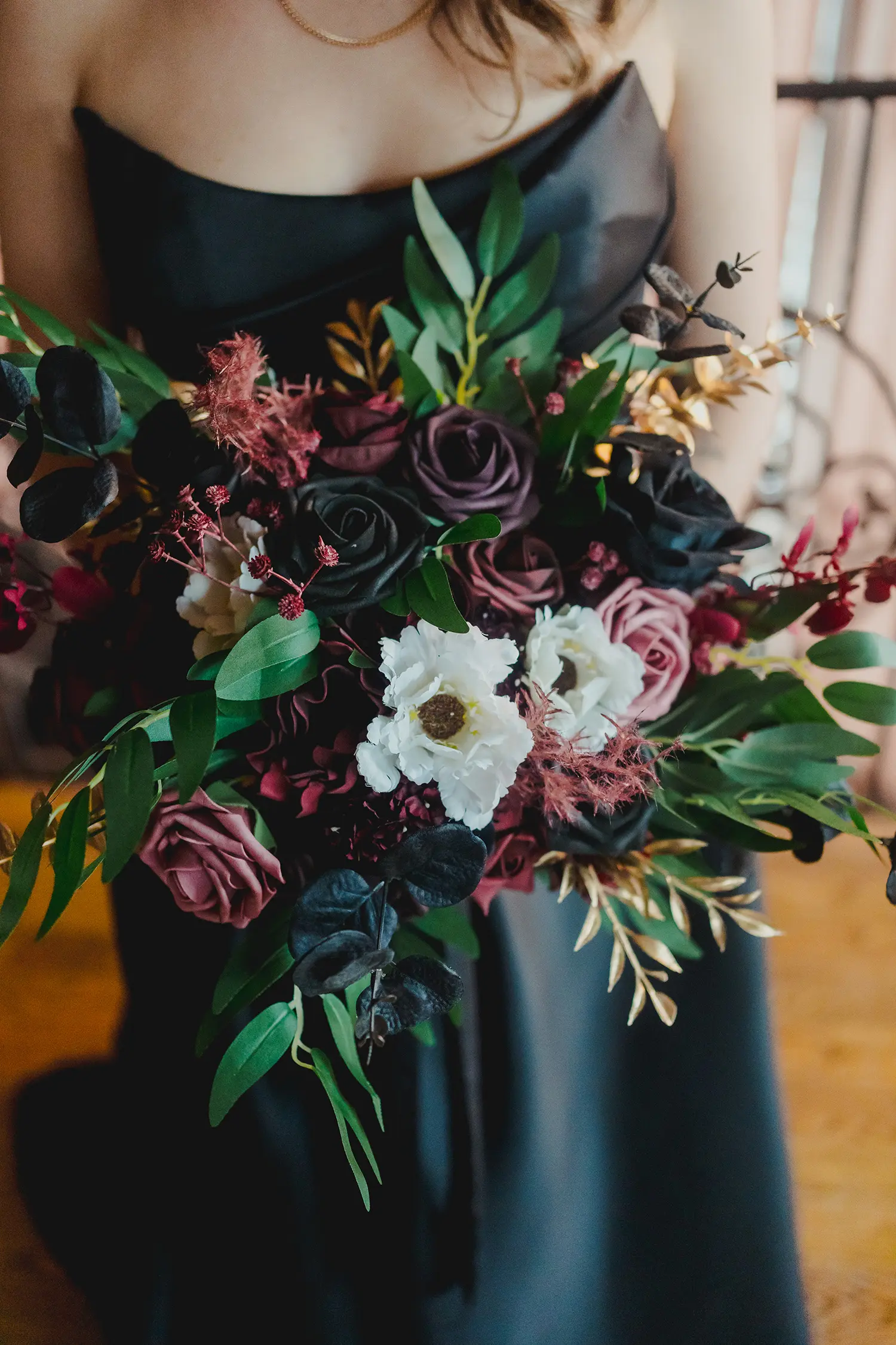 Bride wearing Aspen wedding dress by Sottero and Midgley holding her bouquet