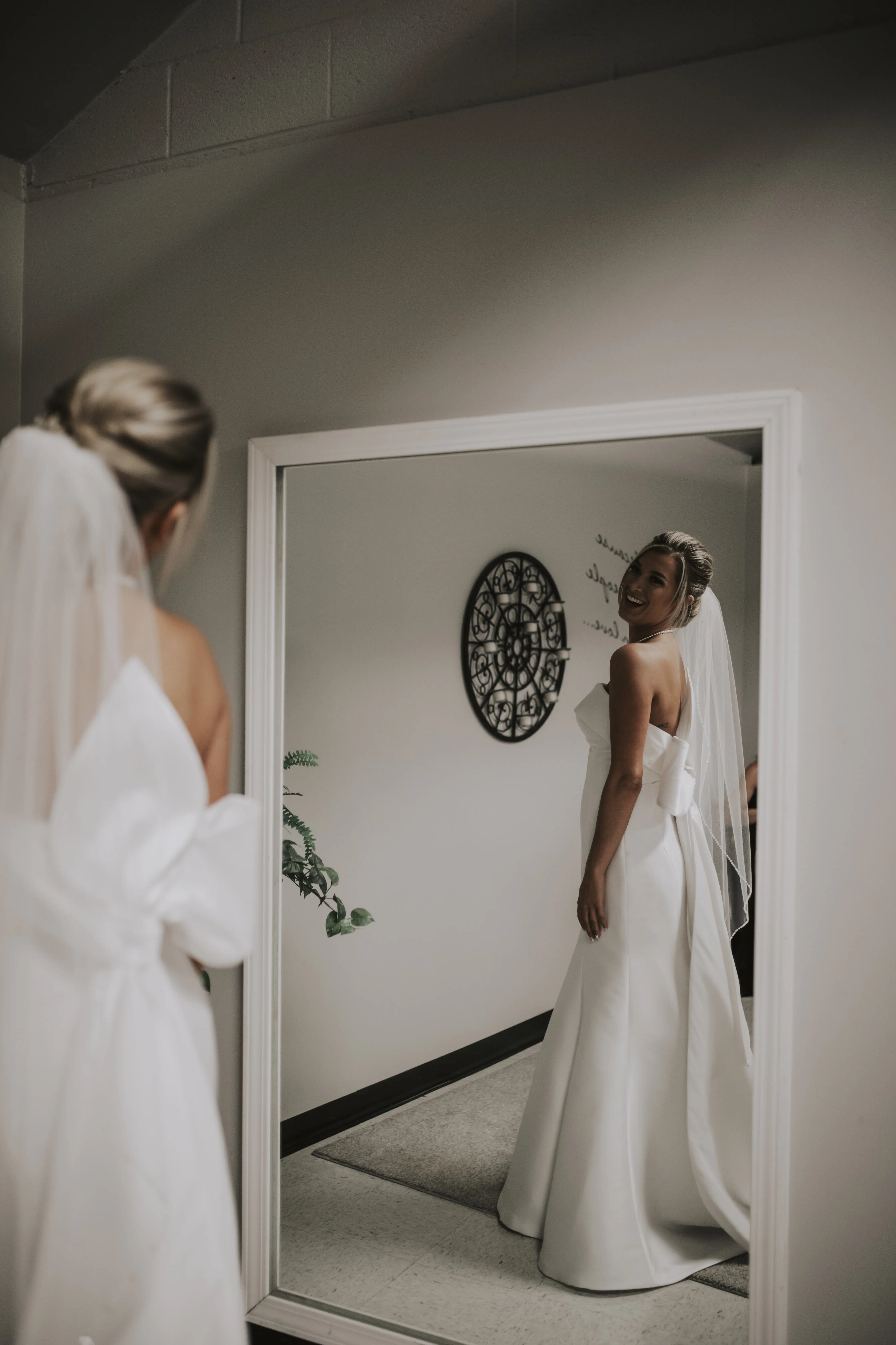 Bride wearing Mitchell wedding dress by Maggie Sottero looking in the mirror