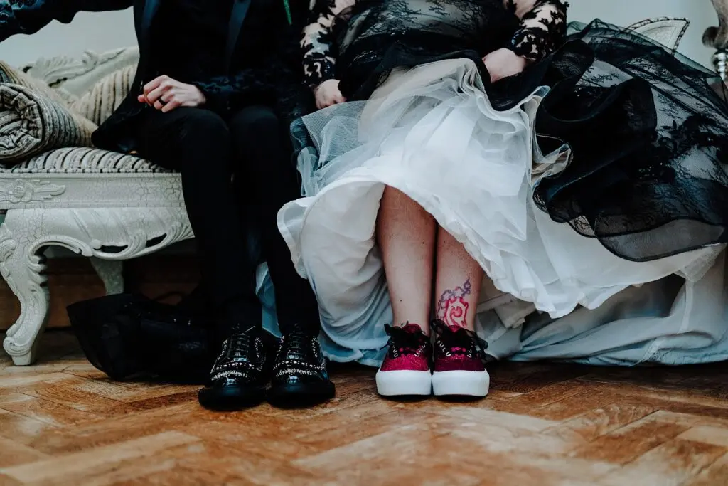 Bride Wearing Gothic Black Wedding Dress Called Zander By Maggie Sottero And Groom Showing Off Their Shoes